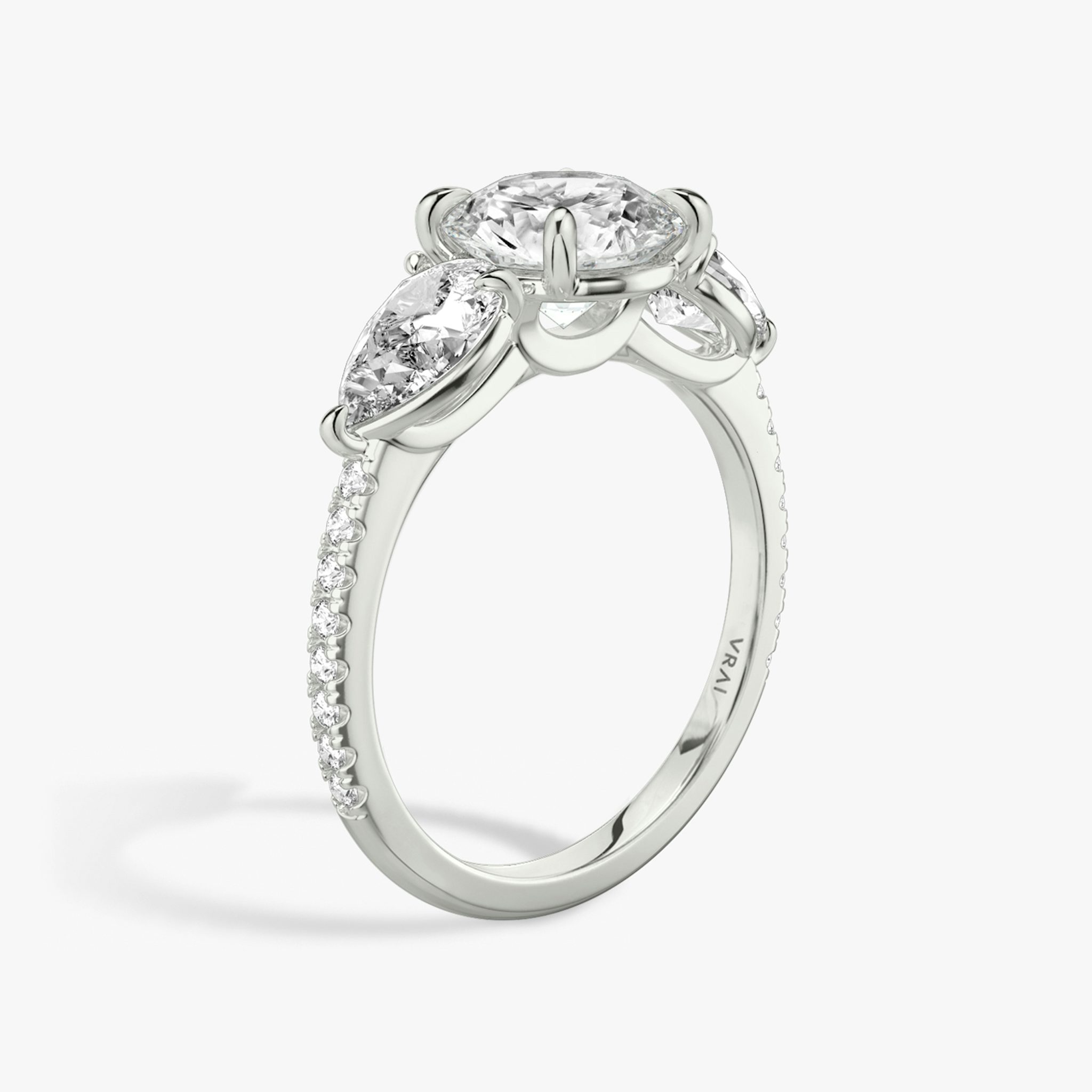 The Three Stone | Round Brilliant | Platinum | bandAccent: Pavé | caratWeight: other | sideStoneCarat: 0.50ct | sideStoneShape: Pear | diamondOrientation: vertical