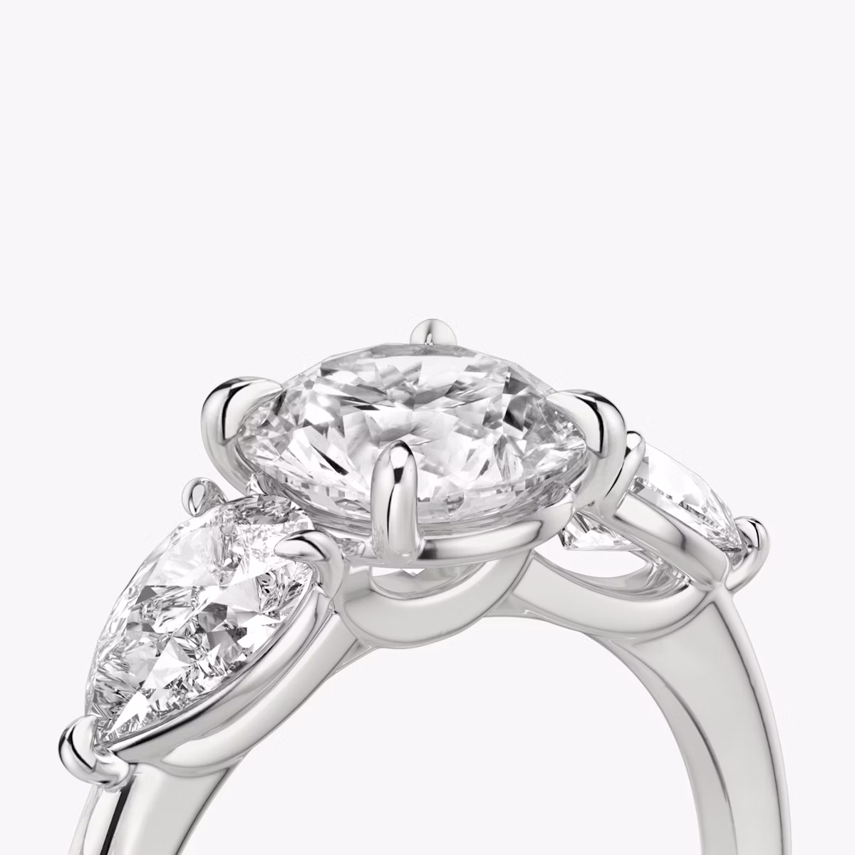 The Three Stone | Round Brilliant | Platinum | bandAccent: Plain | caratWeight: other | sideStoneCarat: 0.50ct | sideStoneShape: Pear | diamondOrientation: vertical