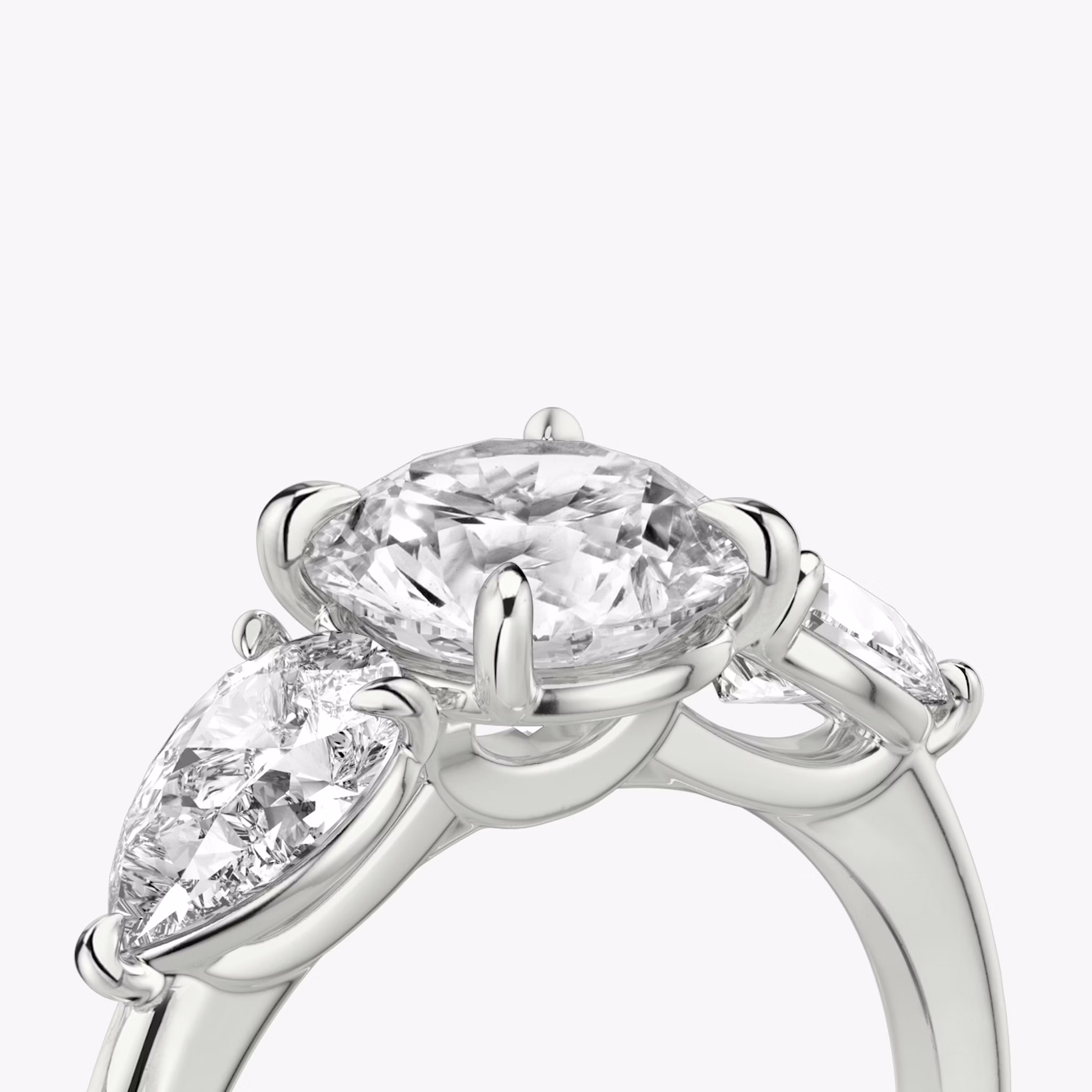 The Three Stone | Round Brilliant | 18k | White Gold | bandAccent: Plain | caratWeight: other | sideStoneCarat: 0.50ct | sideStoneShape: Pear | diamondOrientation: vertical