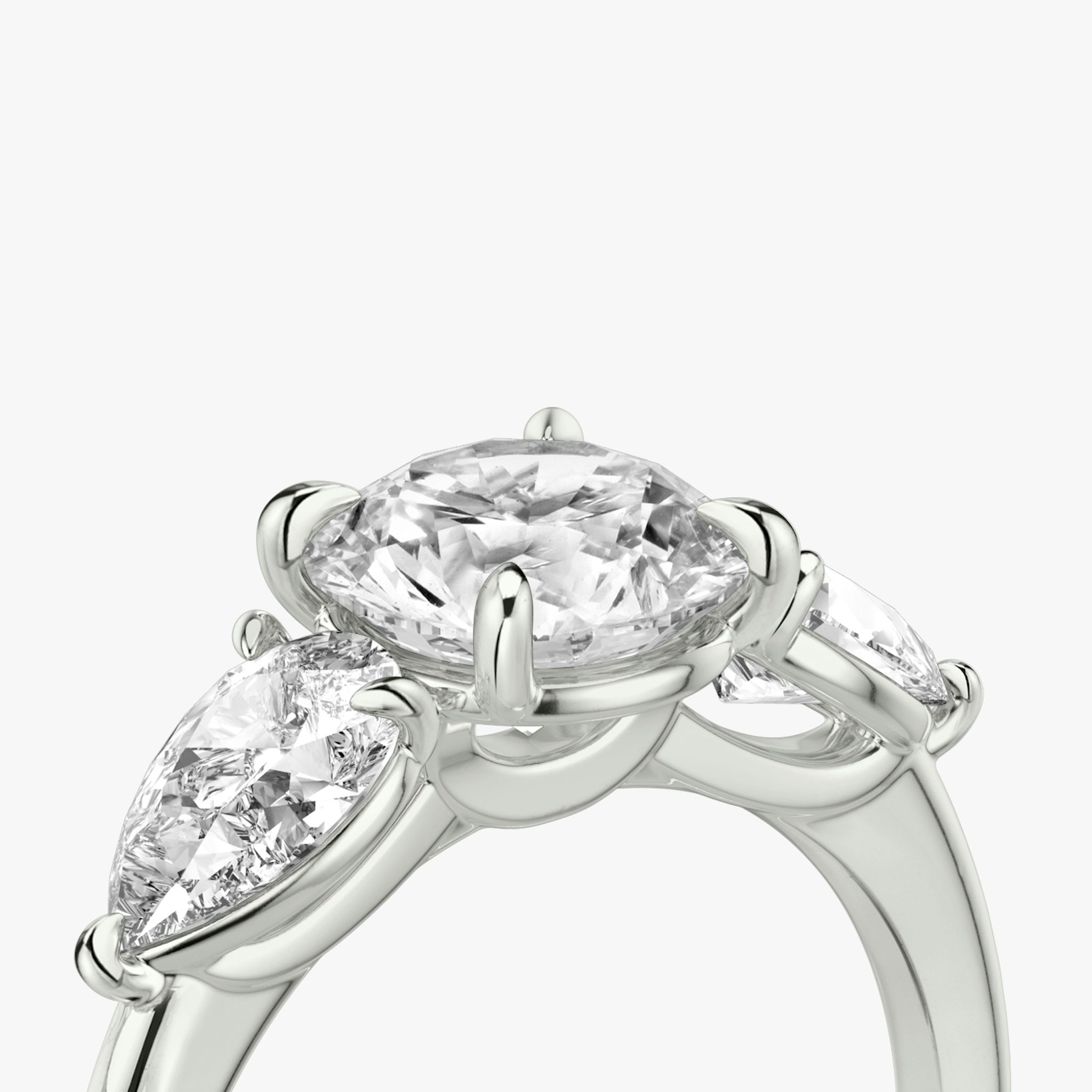 The Three Stone | Round Brilliant | 18k | White Gold | bandAccent: Plain | caratWeight: other | sideStoneCarat: 0.50ct | sideStoneShape: Pear | diamondOrientation: vertical