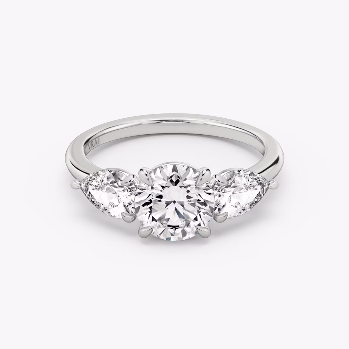 The Three Stone | Round Brilliant | Platinum | bandAccent: Plain | caratWeight: other | sideStoneCarat: 0.50ct | sideStoneShape: Pear | diamondOrientation: vertical