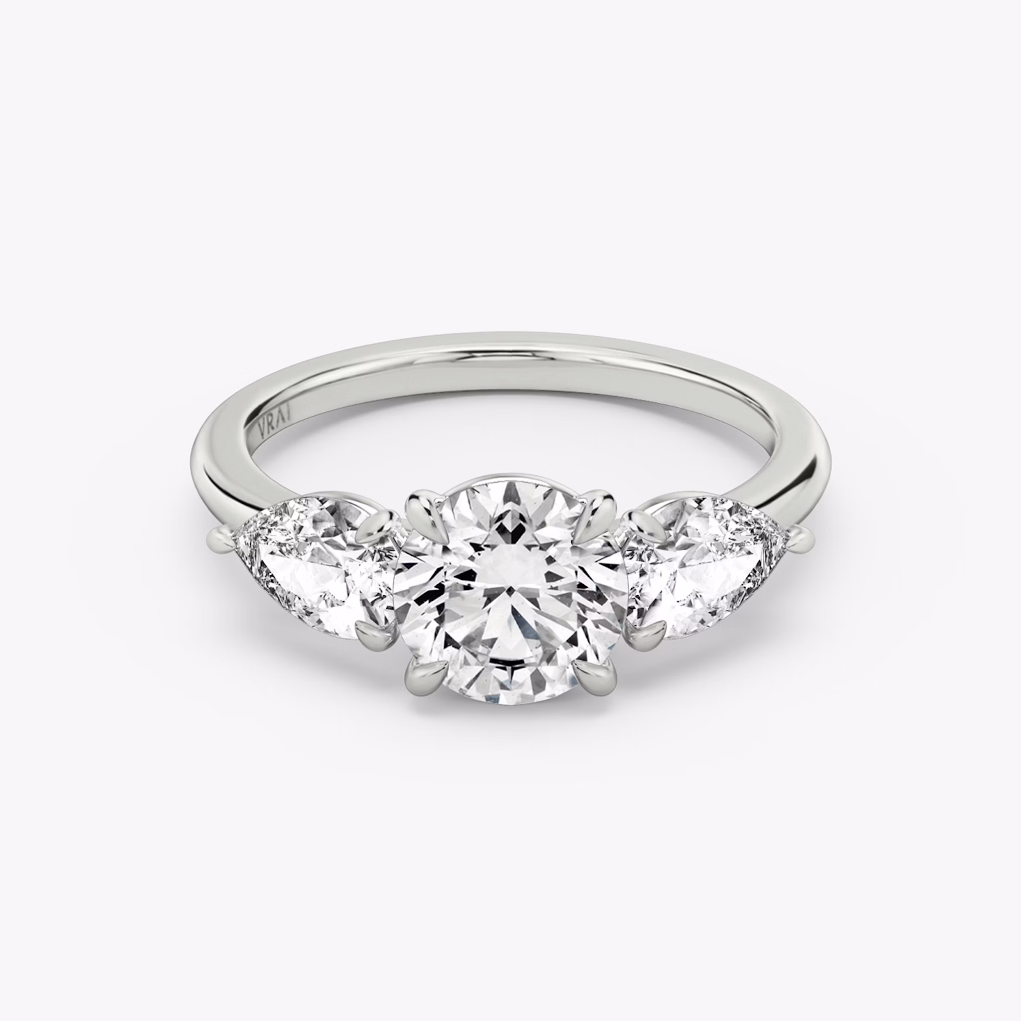 The Three Stone | Round Brilliant | 18k | White Gold | bandAccent: Plain | caratWeight: other | sideStoneCarat: 0.50ct | sideStoneShape: Pear | diamondOrientation: vertical