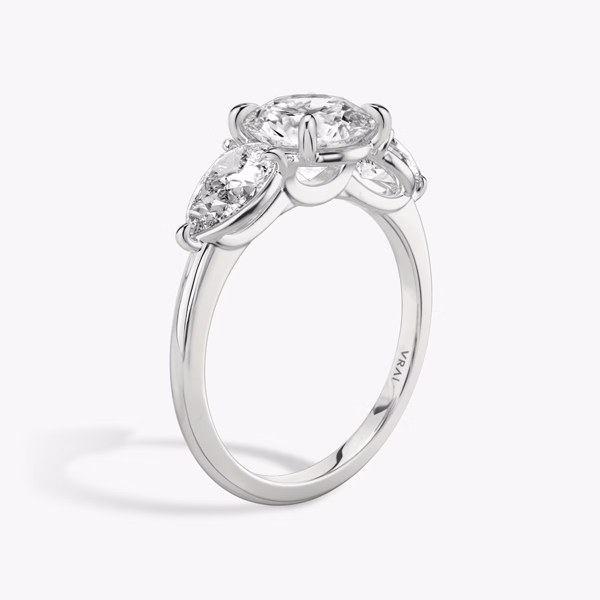 The Three Stone | Round Brilliant | Platinum | bandAccent: Plain | caratWeight: other | sideStoneCarat: 0.50ct | sideStoneShape: Pear | diamondOrientation: vertical