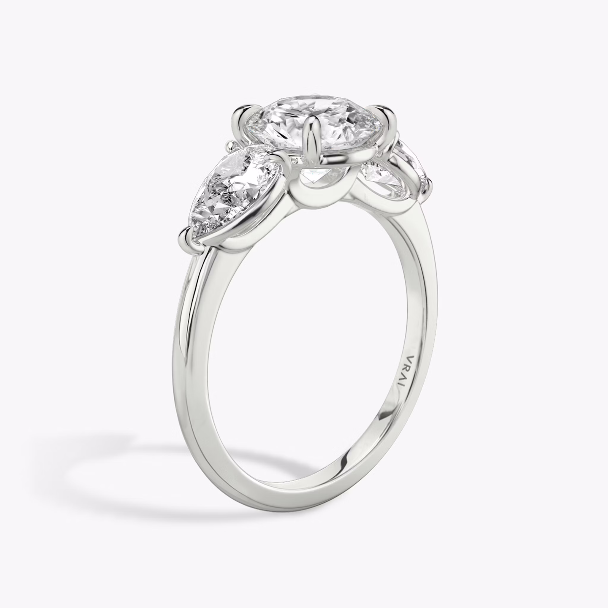 The Three Stone | Round Brilliant | 18k | White Gold | bandAccent: Plain | caratWeight: other | sideStoneCarat: 0.50ct | sideStoneShape: Pear | diamondOrientation: vertical