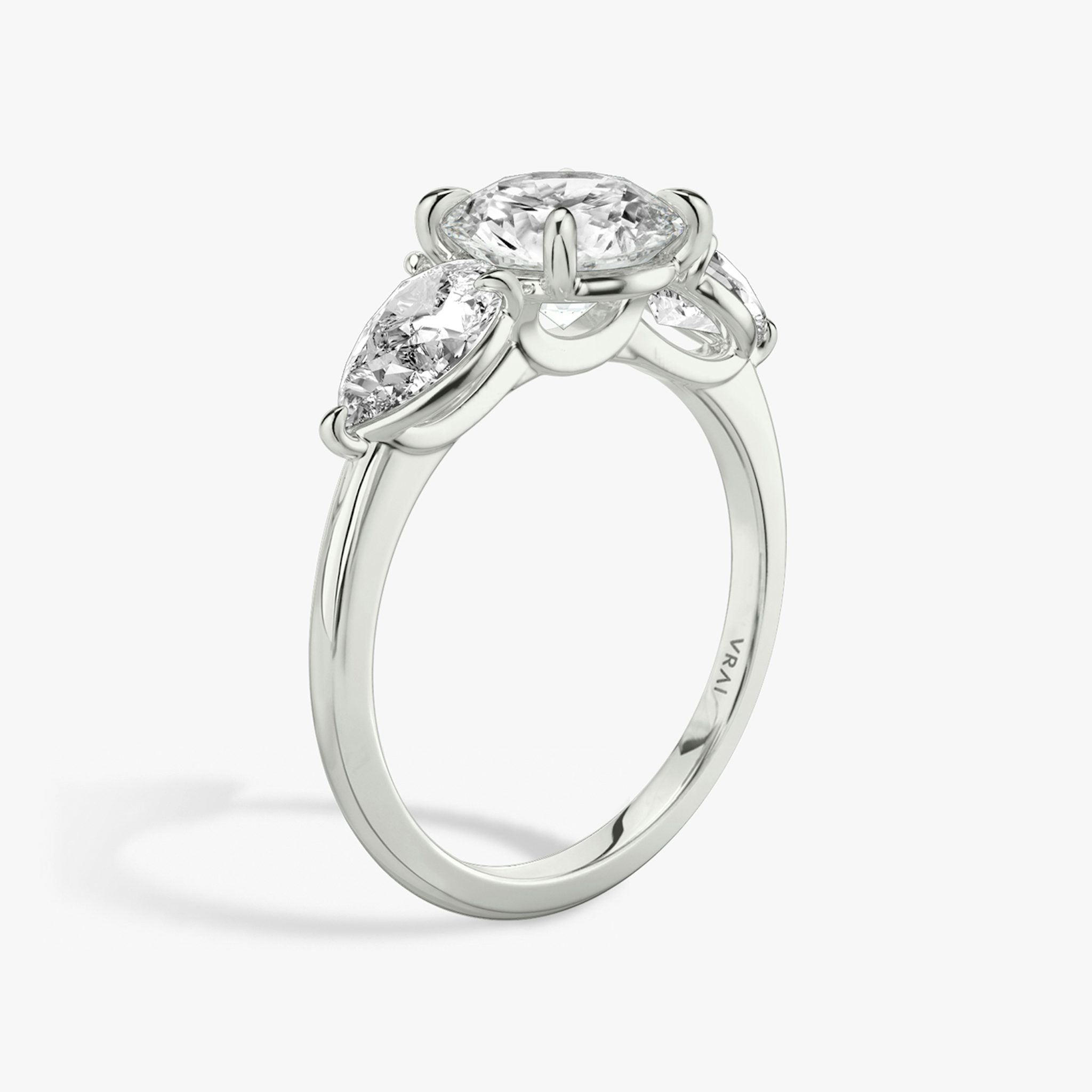 The Three Stone | Round Brilliant | 18k | White Gold | bandAccent: Plain | caratWeight: other | sideStoneCarat: 0.50ct | sideStoneShape: Pear | diamondOrientation: vertical
