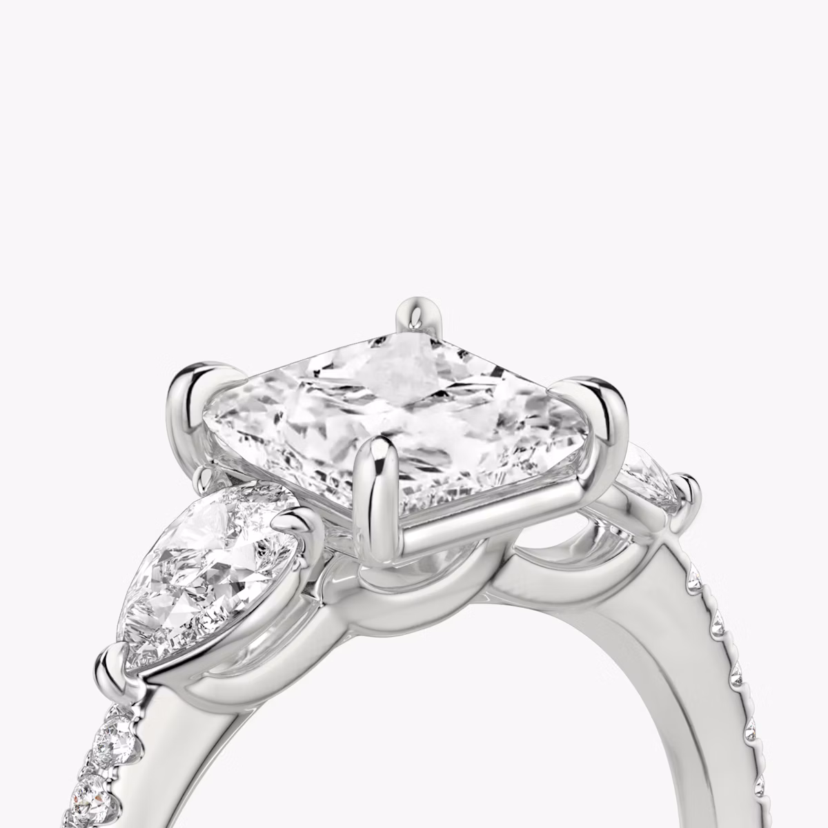The Three Stone | Princess | Platinum | bandAccent: Pavé | sideStoneCarat: 0.25ct | sideStoneShape: Pear | diamondOrientation: vertical | caratWeight: other