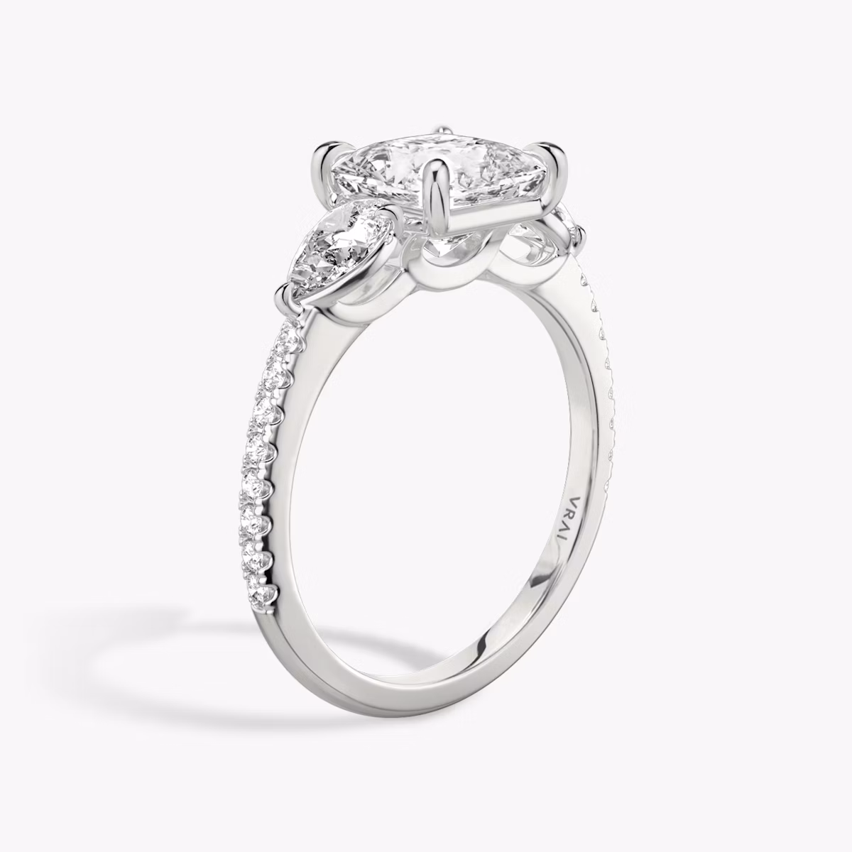 The Three Stone | Princess | Platinum | bandAccent: Pavé | sideStoneCarat: 0.25ct | sideStoneShape: Pear | diamondOrientation: vertical | caratWeight: other