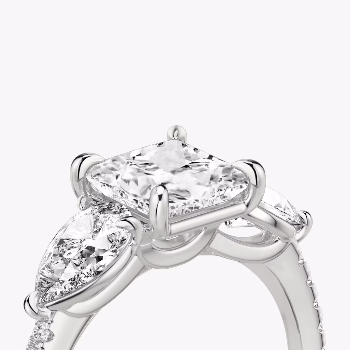 The Three Stone | Princess | Platinum | bandAccent: Pavé | sideStoneCarat: 0.50ct | sideStoneShape: Pear | diamondOrientation: vertical | caratWeight: other