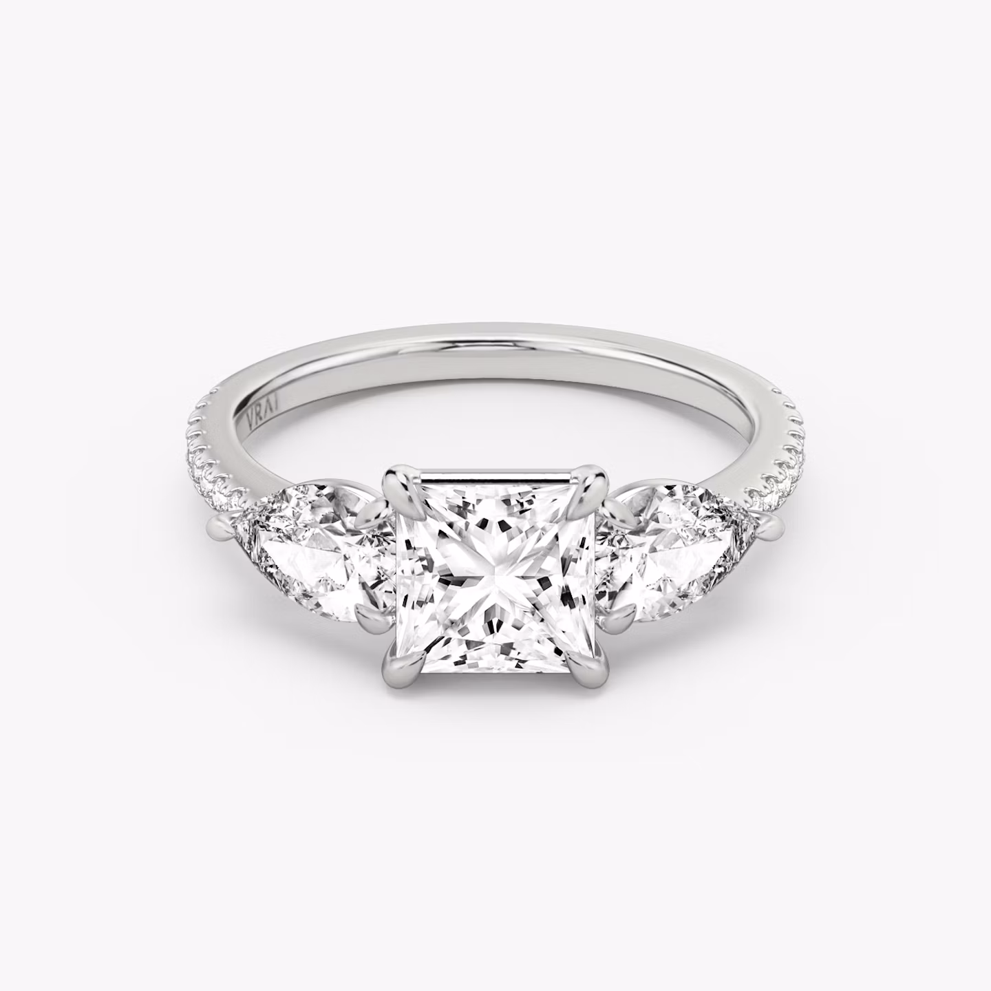 Anillo de compromiso Three Stone | Princesa | 18k | Oro blanco | bandAccent: Pavé | sideStoneCarat: 0.50ct | sideStoneShape: Pera | diamondOrientation: vertical | caratWeight: other