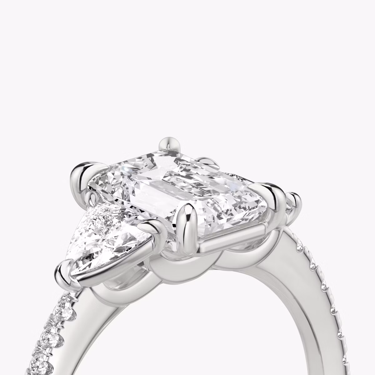 The Three Stone | Emerald | Platinum | bandAccent: Pavé | sideStoneCarat: 0.25ct | sideStoneShape: Trillion | diamondOrientation: vertical | caratWeight: other