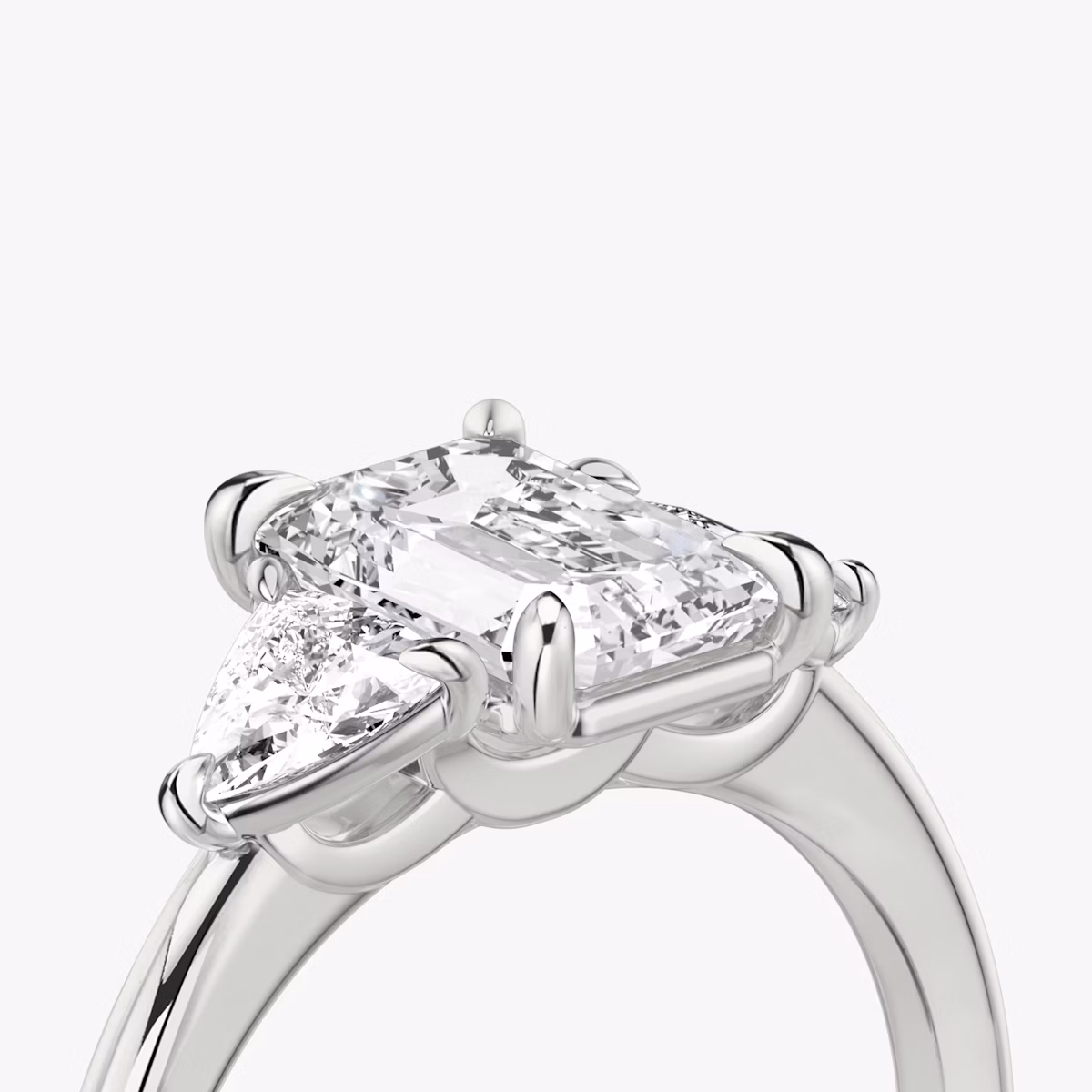 The Three Stone | Emerald | Platinum | bandAccent: Plain | sideStoneCarat: 0.25ct | sideStoneShape: Trillion | diamondOrientation: vertical | caratWeight: other