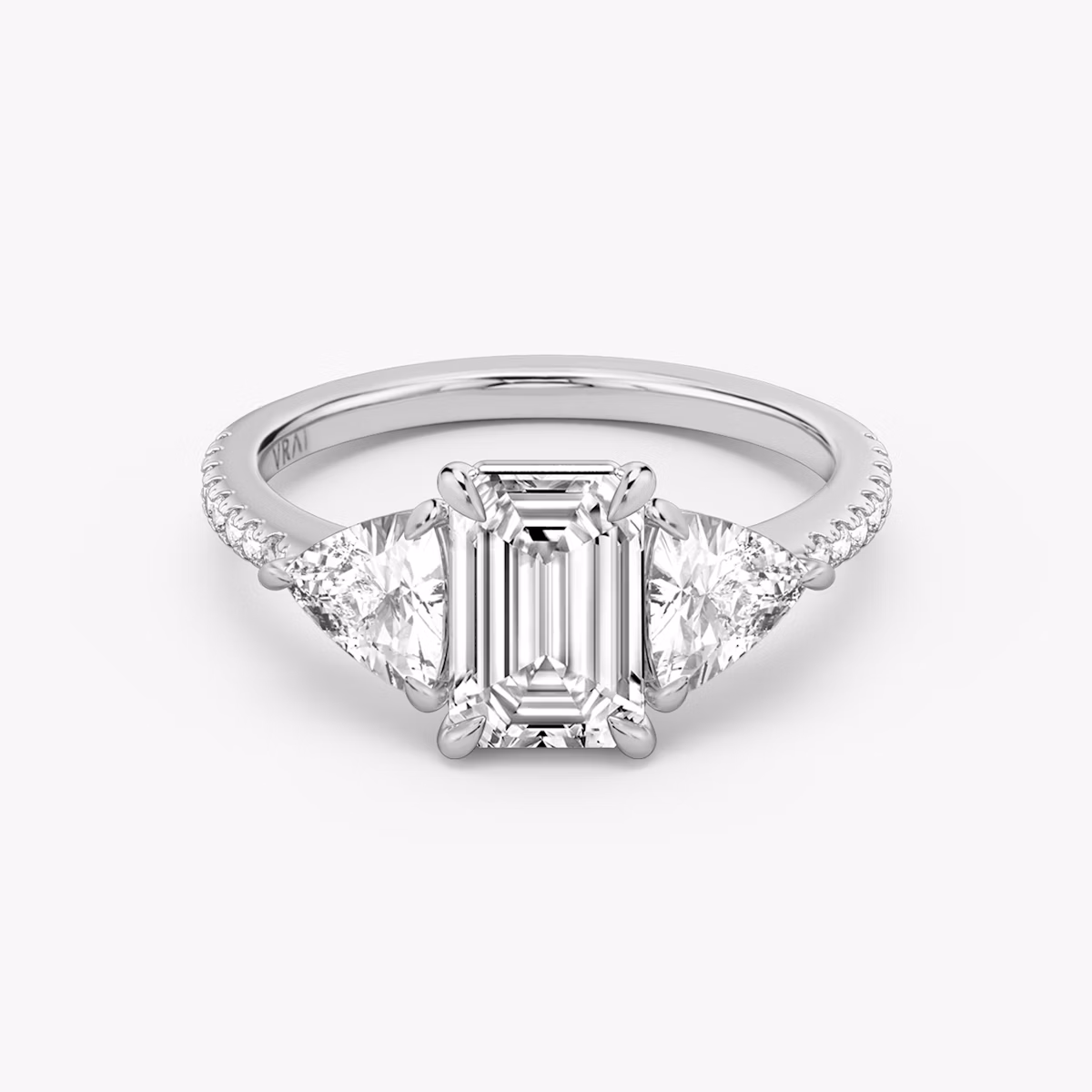 The Three Stone | Emerald | Platinum | bandAccent: Pavé | sideStoneCarat: 0.50ct | sideStoneShape: Trillion | diamondOrientation: vertical | caratWeight: other