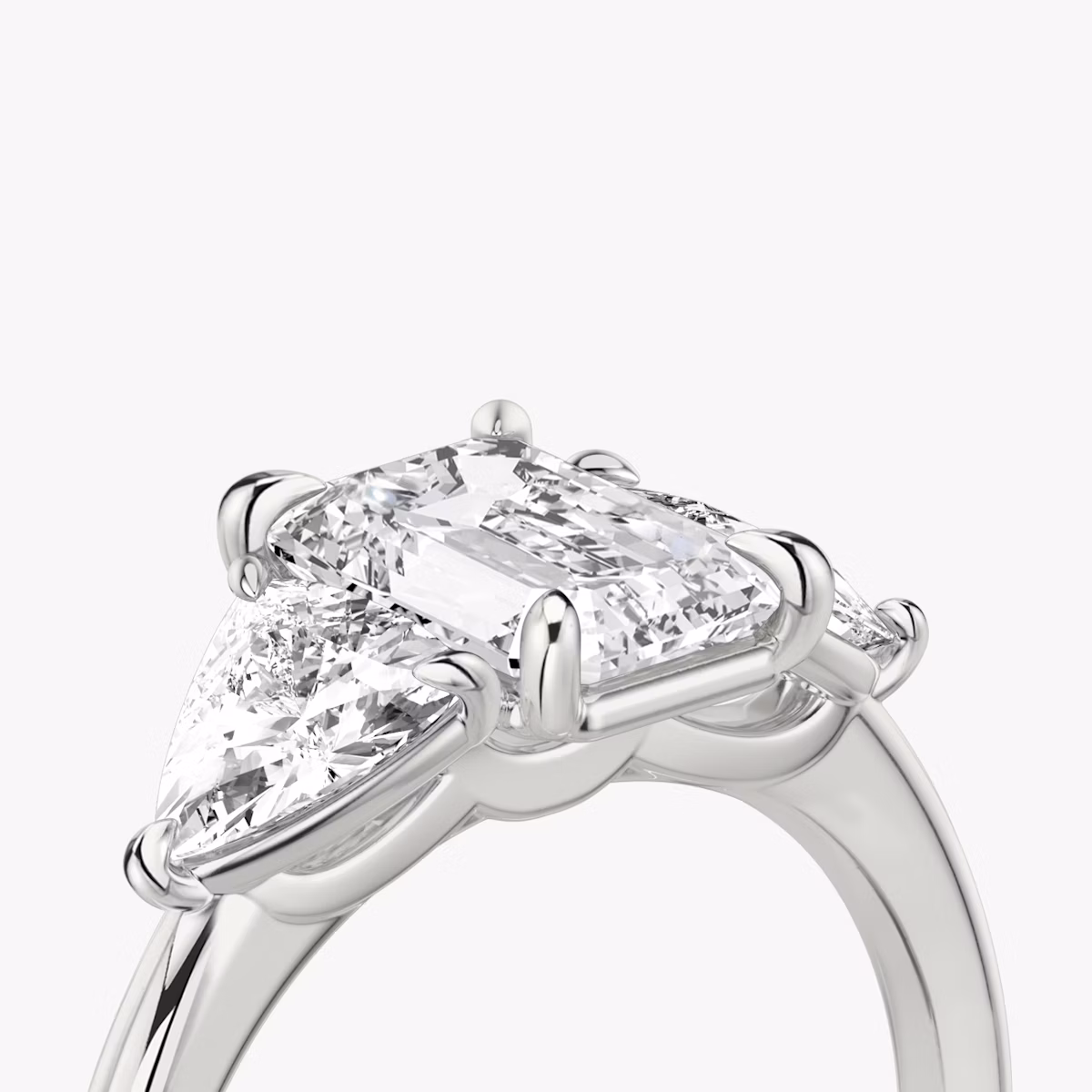 The Three Stone | Emerald | Platinum | bandAccent: Plain | sideStoneCarat: 0.50ct | sideStoneShape: Trillion | diamondOrientation: vertical | caratWeight: other