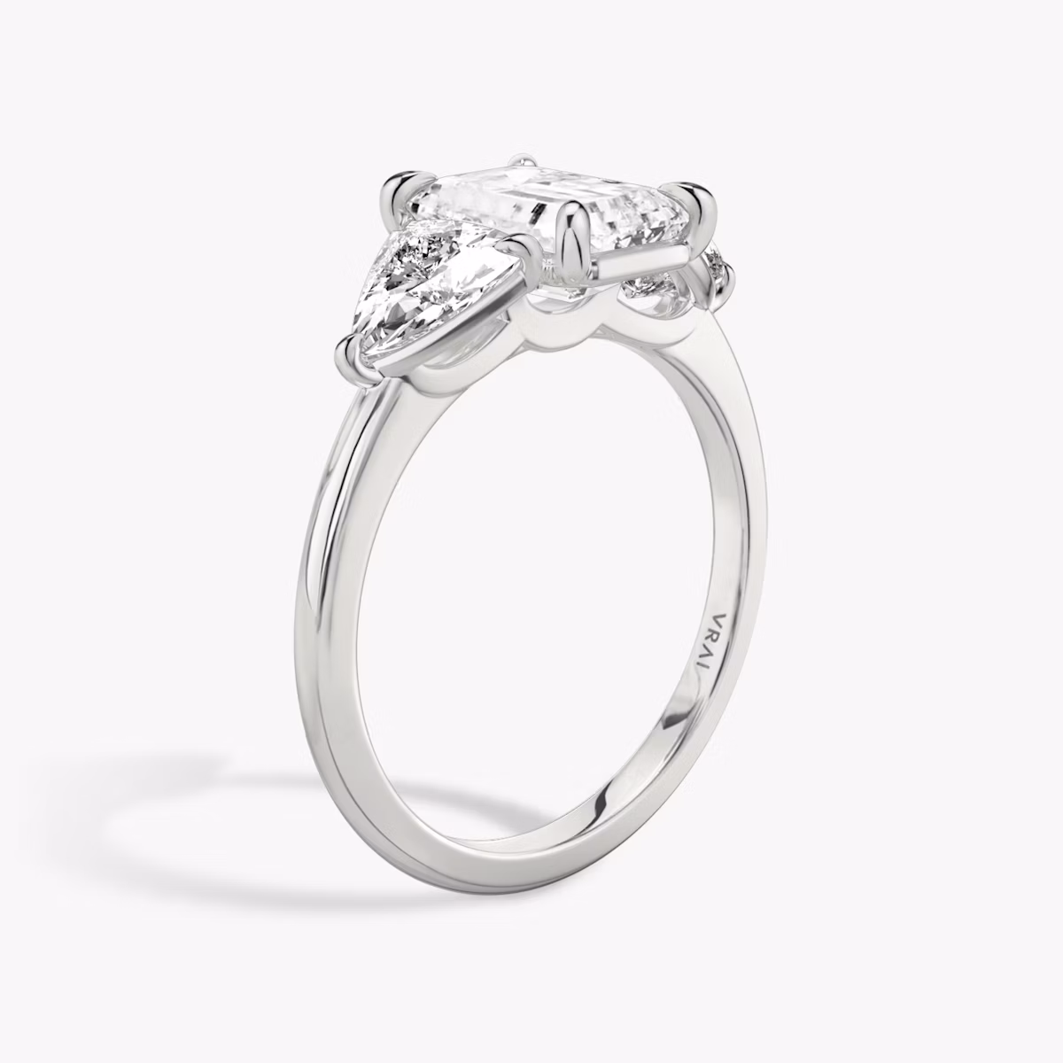 The Three Stone | Emerald | Platinum | bandAccent: Plain | sideStoneCarat: 0.50ct | sideStoneShape: Trillion | diamondOrientation: vertical | caratWeight: other