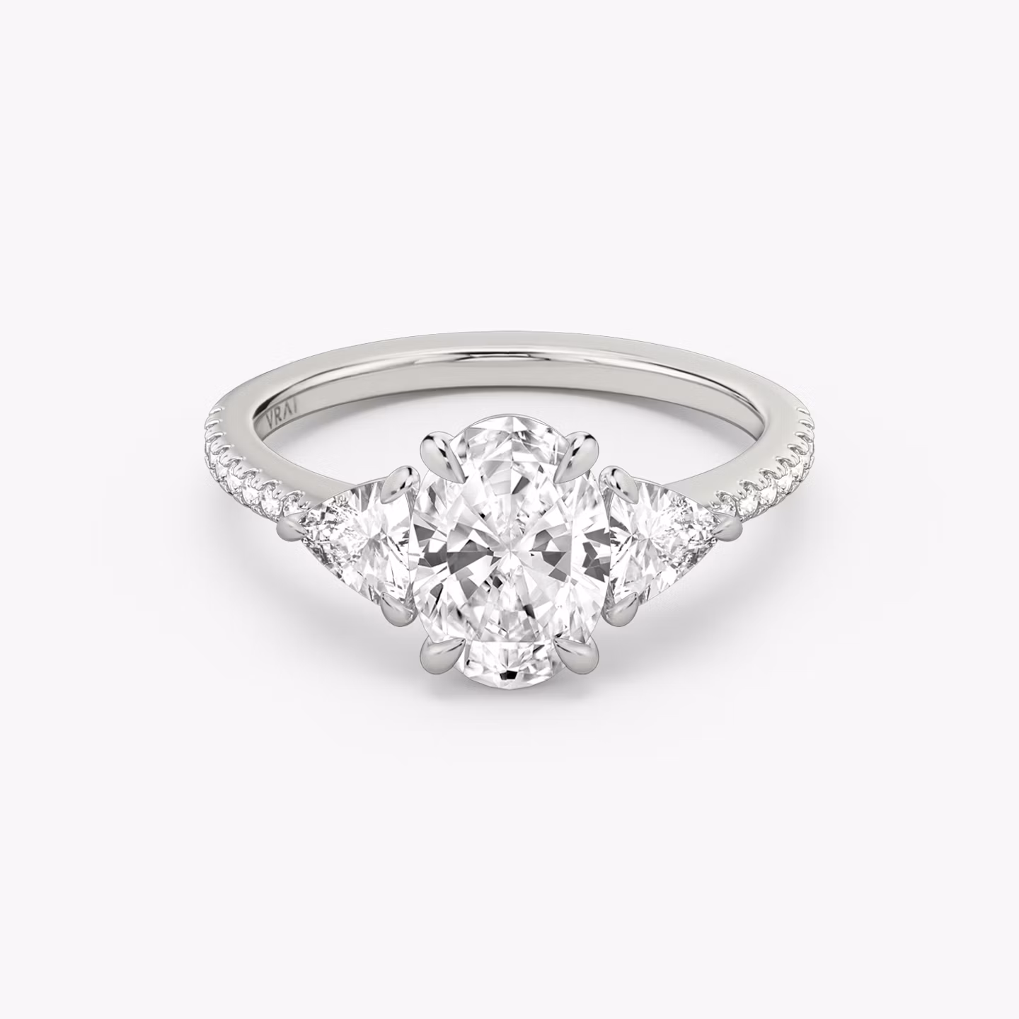 The Three Stone | Oval | 18k | White Gold | bandAccent: Pavé | sideStoneCarat: 0.25ct | sideStoneShape: Trillion | diamondOrientation: vertical | caratWeight: other
