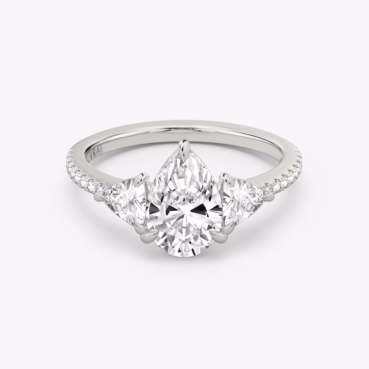The Three Stone | Pear | Platinum | bandAccent: Pavé | sideStoneCarat: 0.25ct | sideStoneShape: Trillion | diamondOrientation: vertical | caratWeight: other