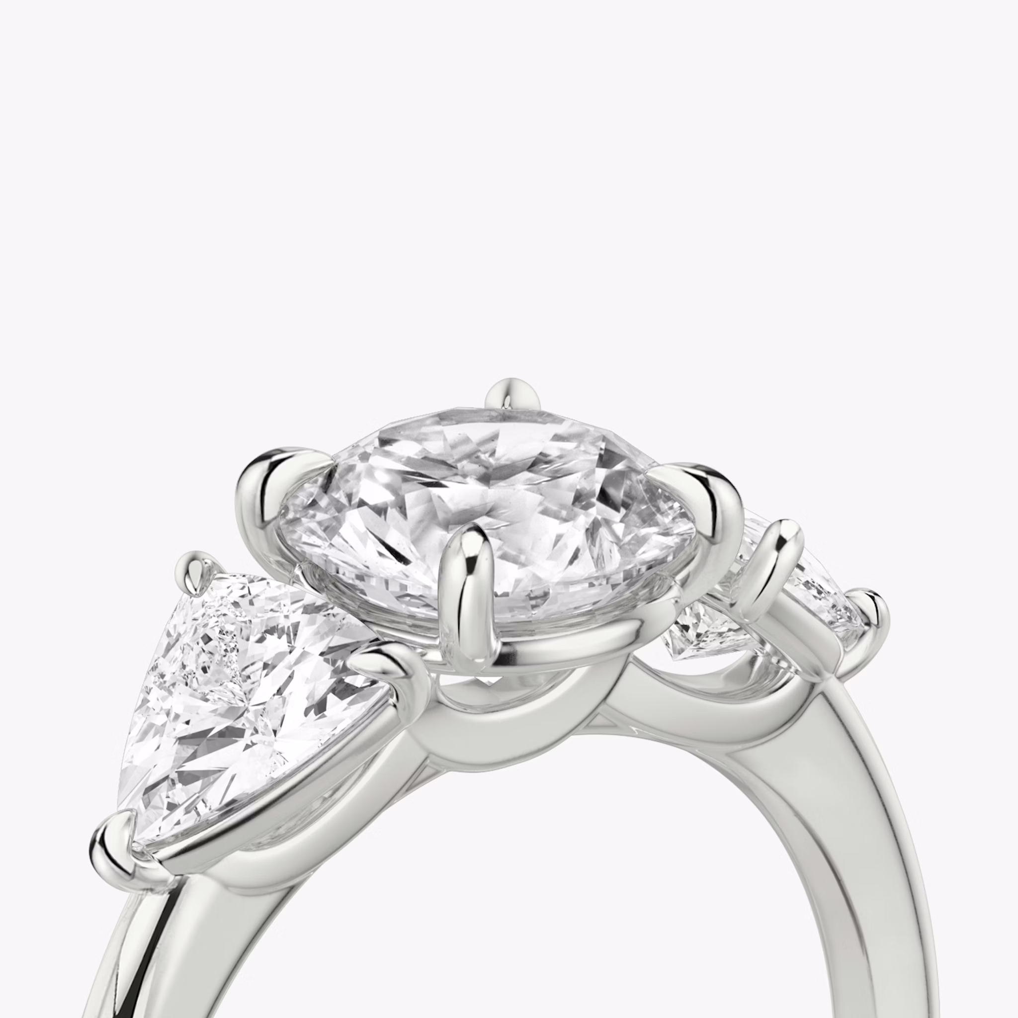 The Three Stone | Round Brilliant | 18k | White Gold | bandAccent: Plain | caratWeight: other | sideStoneCarat: 0.50ct | sideStoneShape: Trillion | diamondOrientation: vertical