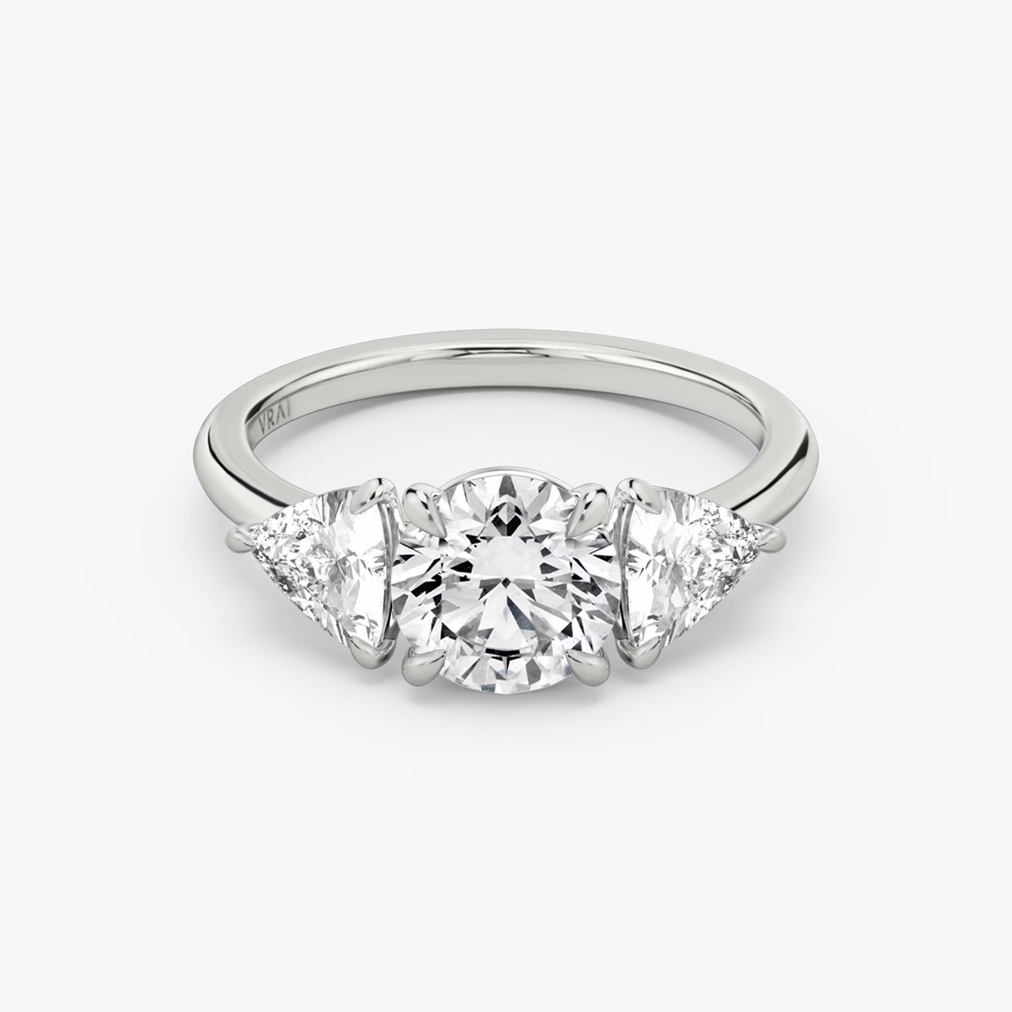 The Three Stone | Round Brilliant | 18k | White Gold | bandAccent: Plain | caratWeight: other | sideStoneCarat: 0.50ct | sideStoneShape: Trillion | diamondOrientation: vertical