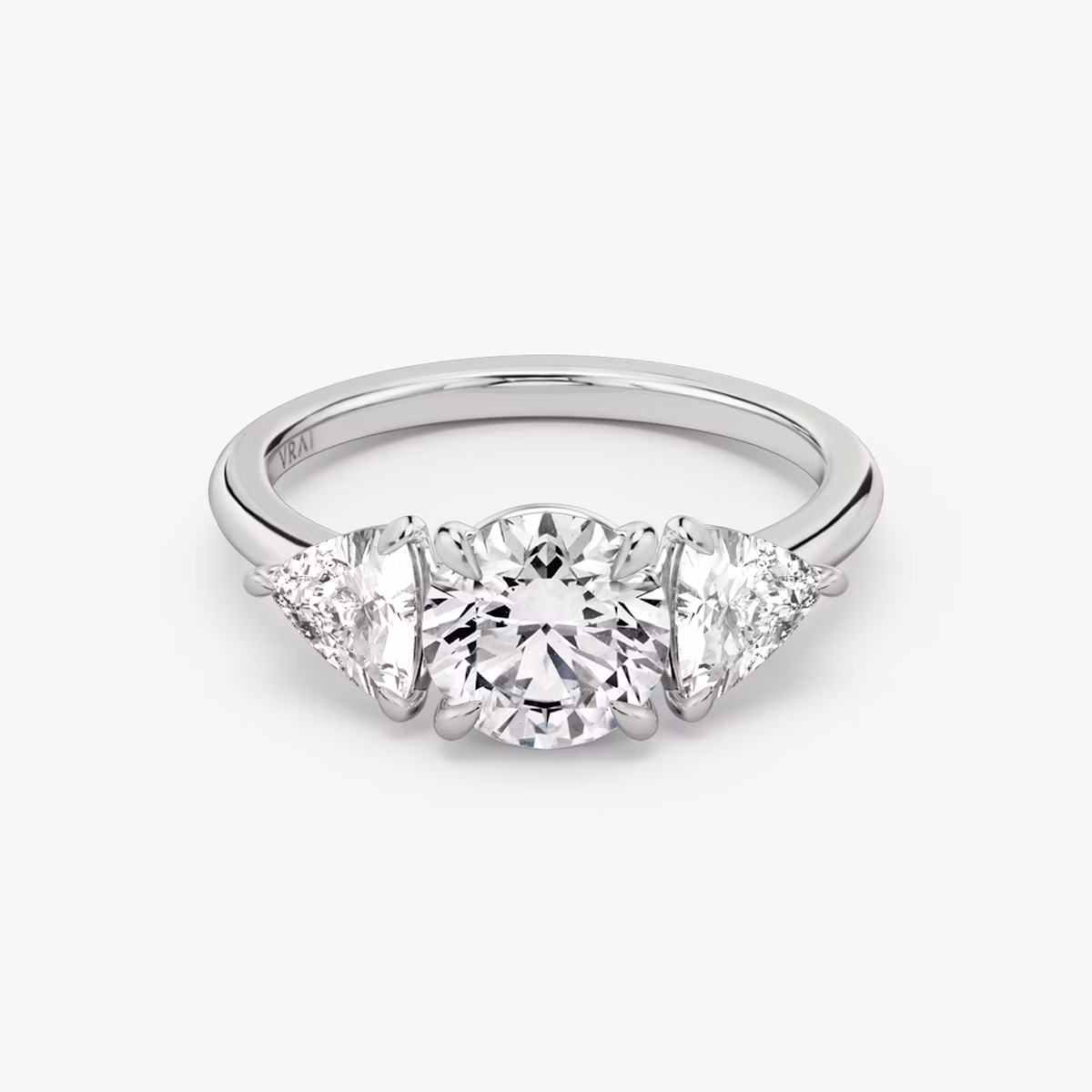 The Three Stone | Round Brilliant | Platinum | bandAccent: Plain | caratWeight: other | sideStoneCarat: 0.50ct | sideStoneShape: Trillion | diamondOrientation: vertical