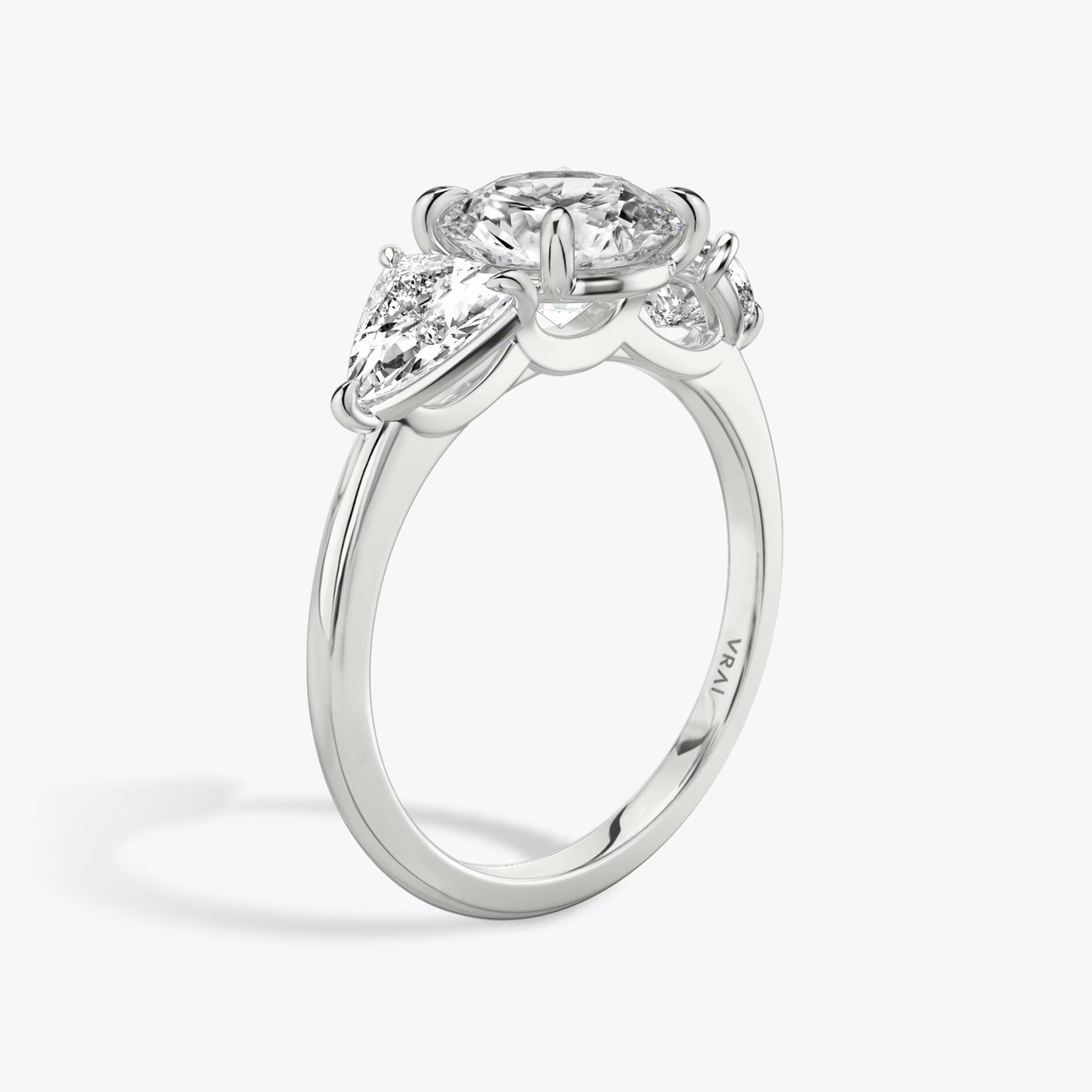 The Three Stone | Round Brilliant | Platinum | bandAccent: Plain | caratWeight: other | sideStoneCarat: 0.50ct | sideStoneShape: Trillion | diamondOrientation: vertical
