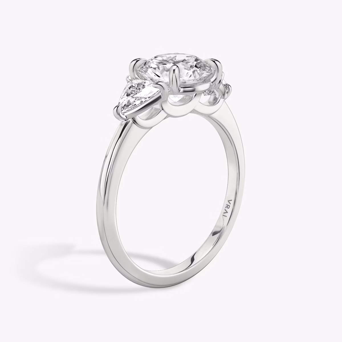 The Three Stone | Round Brilliant | 18k | White Gold | bandAccent: Plain | caratWeight: other | sideStoneCarat: 0.25ct | sideStoneShape: Trillion | diamondOrientation: vertical