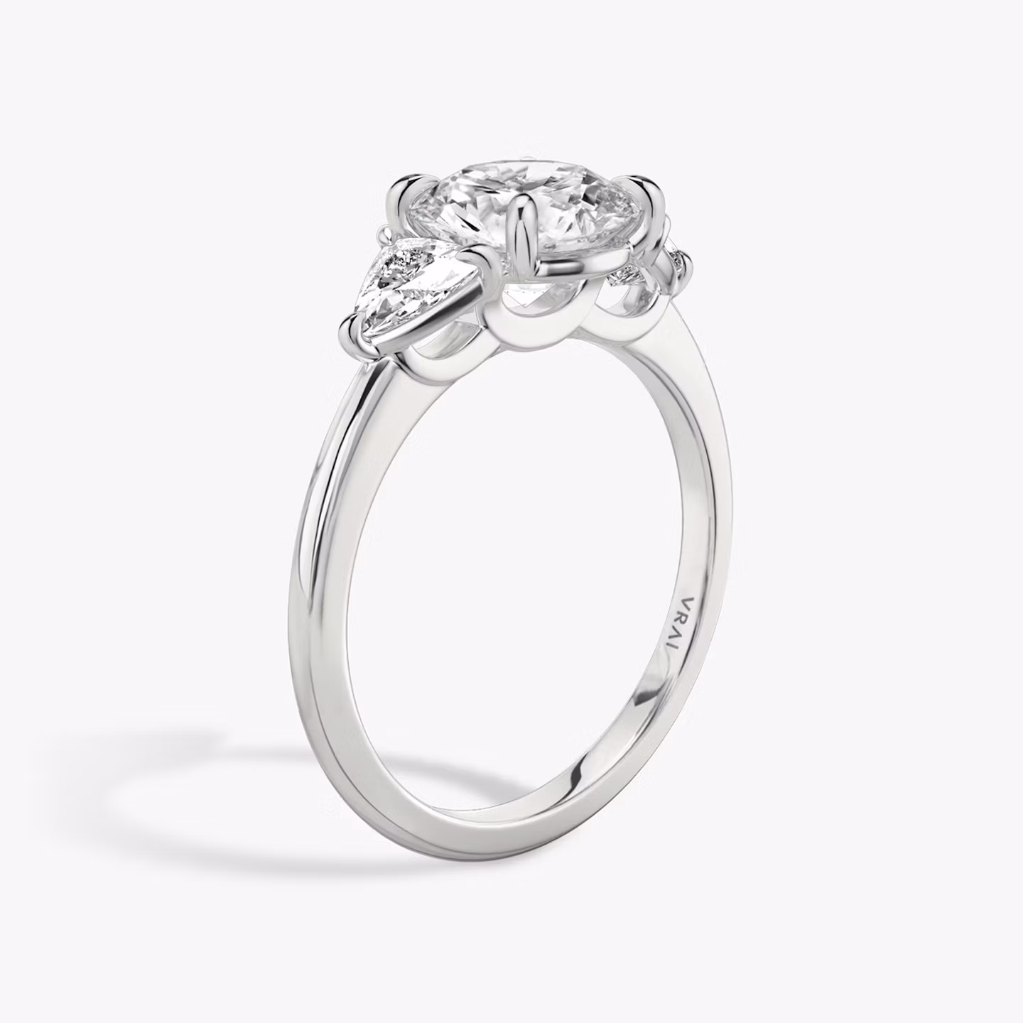 The Three Stone | Round Brilliant | 18k | White Gold | bandAccent: Plain | caratWeight: other | sideStoneCarat: 0.25ct | sideStoneShape: Trillion | diamondOrientation: vertical