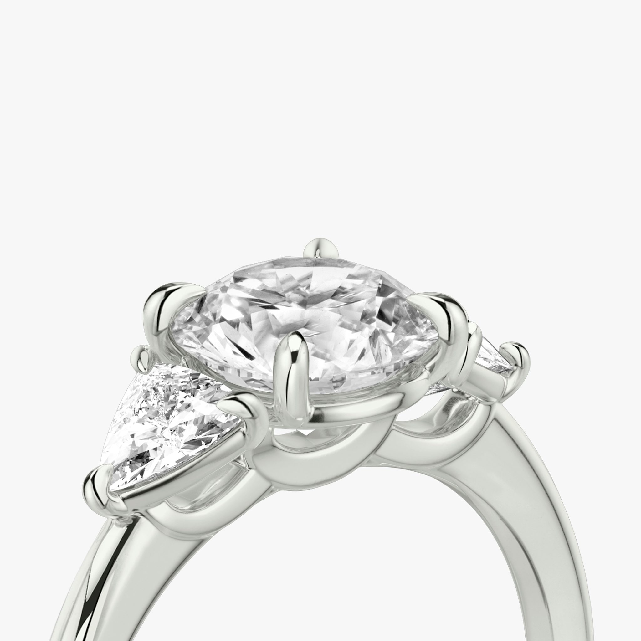 The Three Stone | Round Brilliant | Platinum | bandAccent: Plain | caratWeight: other | sideStoneCarat: 0.25ct | sideStoneShape: Trillion | diamondOrientation: vertical
