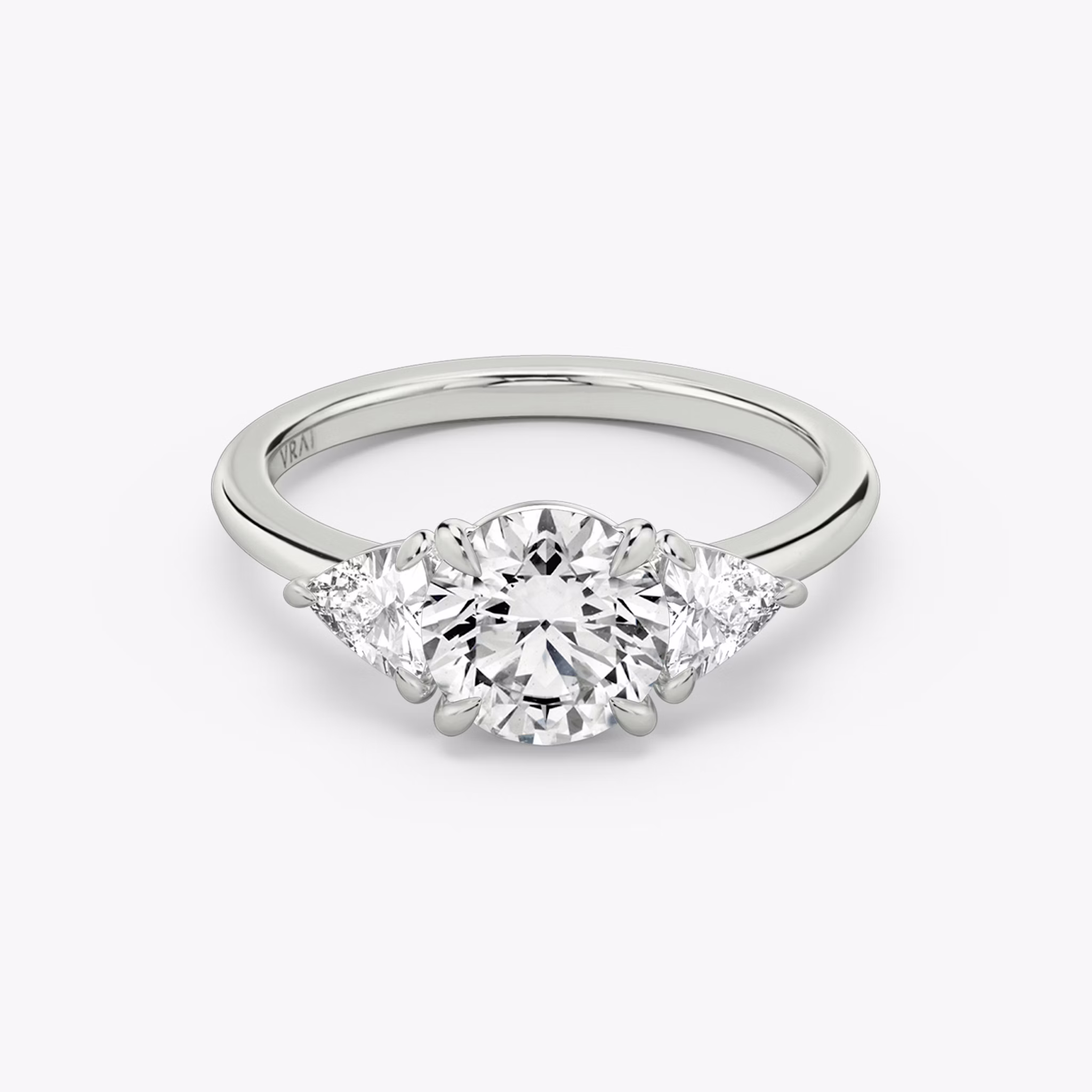 The Three Stone | Round Brilliant | Platinum | bandAccent: Plain | caratWeight: other | sideStoneCarat: 0.25ct | sideStoneShape: Trillion | diamondOrientation: vertical