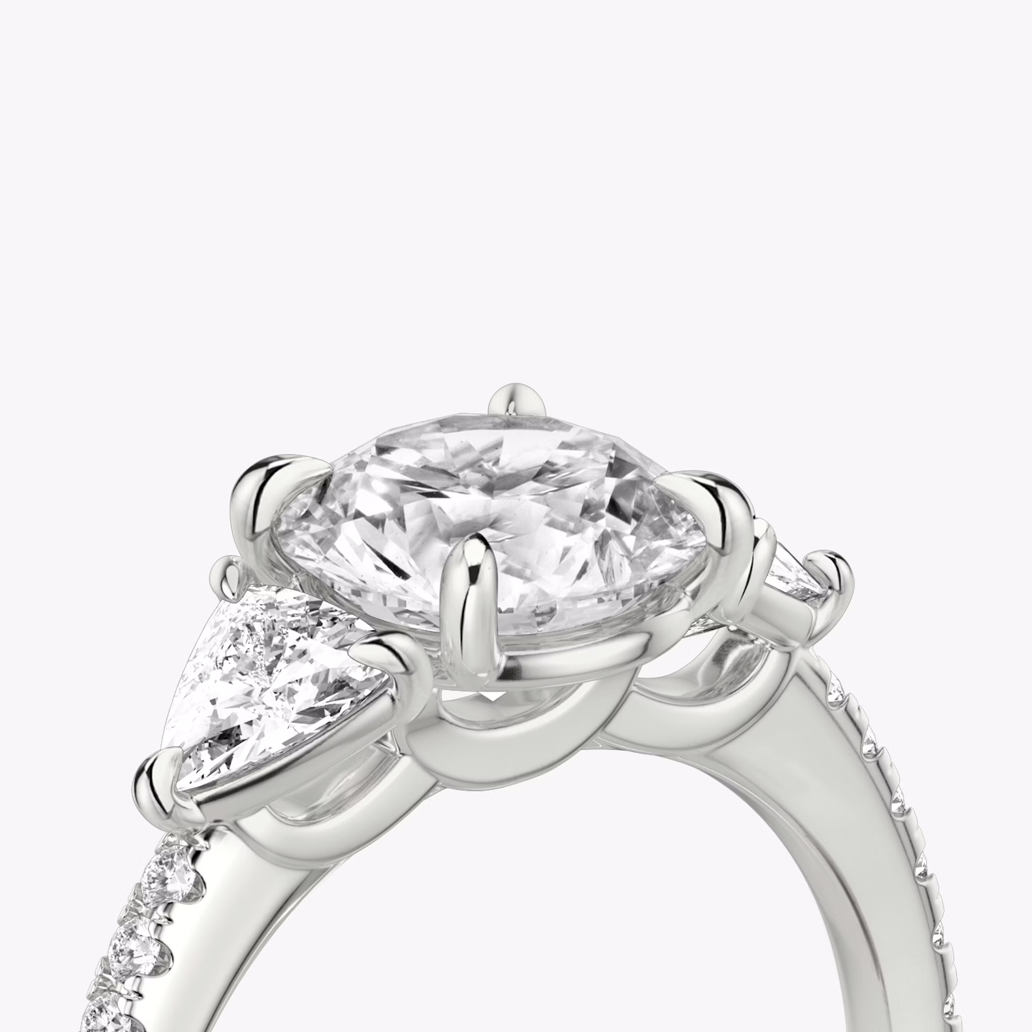The Three Stone | Round Brilliant | 18k | White Gold | bandAccent: Pavé | caratWeight: other | sideStoneCarat: 0.25ct | sideStoneShape: Trillion | diamondOrientation: vertical