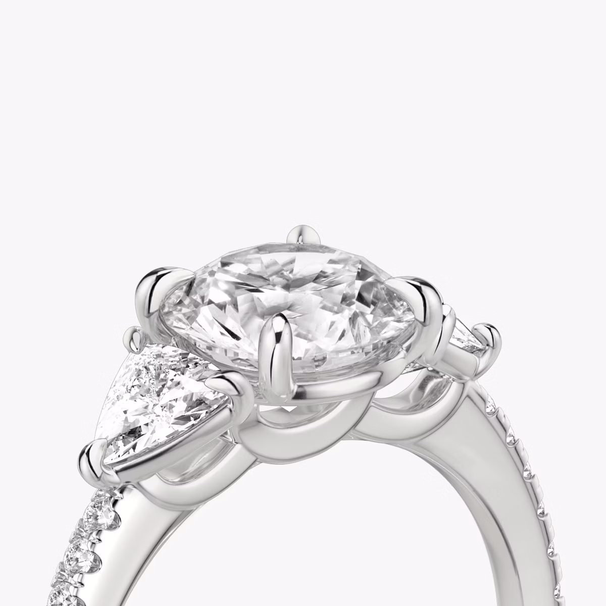 The Three Stone | Round Brilliant | Platinum | bandAccent: Pavé | caratWeight: other | sideStoneCarat: 0.25ct | sideStoneShape: Trillion | diamondOrientation: vertical