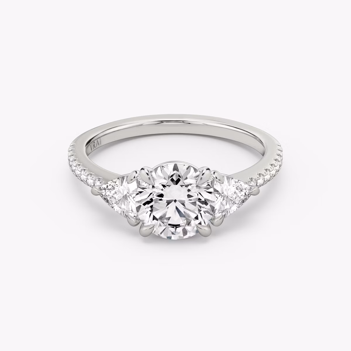 The Three Stone | Round Brilliant | Platinum | bandAccent: Pavé | caratWeight: other | sideStoneCarat: 0.25ct | sideStoneShape: Trillion | diamondOrientation: vertical