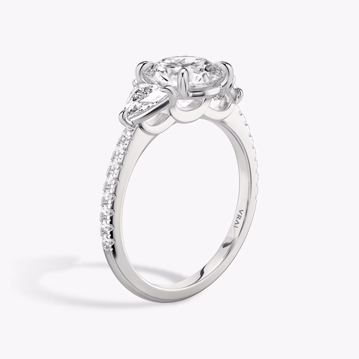 The Three Stone | Round Brilliant | Platinum | bandAccent: Pavé | caratWeight: other | sideStoneCarat: 0.25ct | sideStoneShape: Trillion | diamondOrientation: vertical