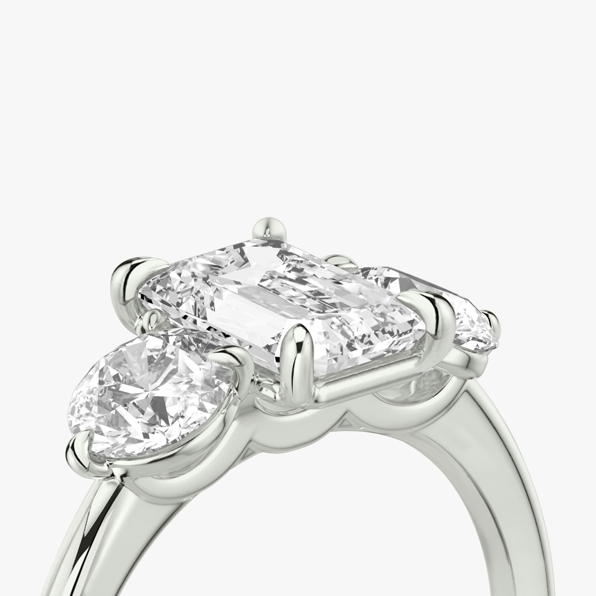 The Three Stone | Emerald | Platinum | bandAccent: Plain | sideStoneCarat: 0.50ct | sideStoneShape: Round Brilliant | diamondOrientation: vertical | caratWeight: other