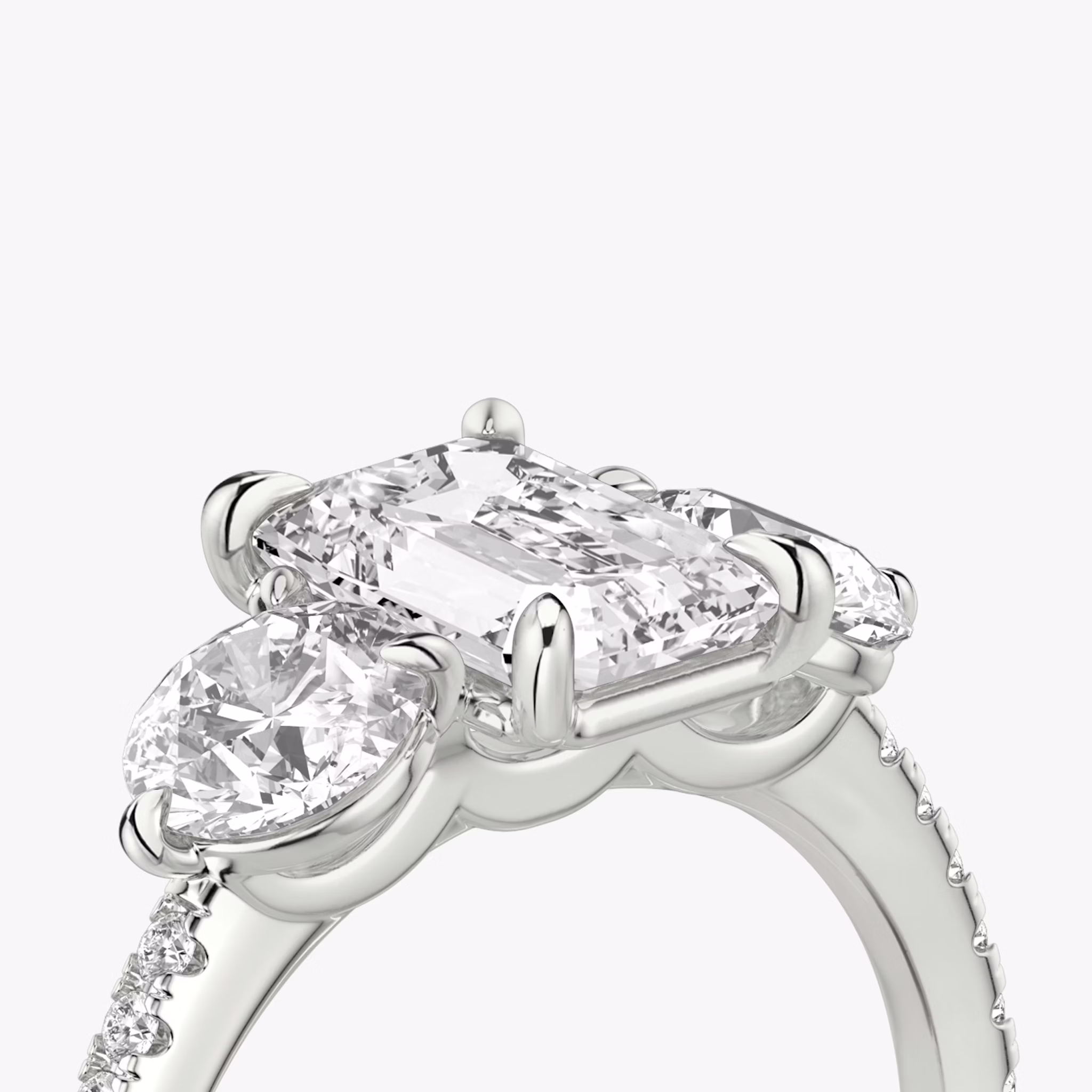 The Three Stone | Emerald | 18k | White Gold | bandAccent: Pavé | sideStoneCarat: 0.50ct | sideStoneShape: Round Brilliant | diamondOrientation: vertical | caratWeight: other