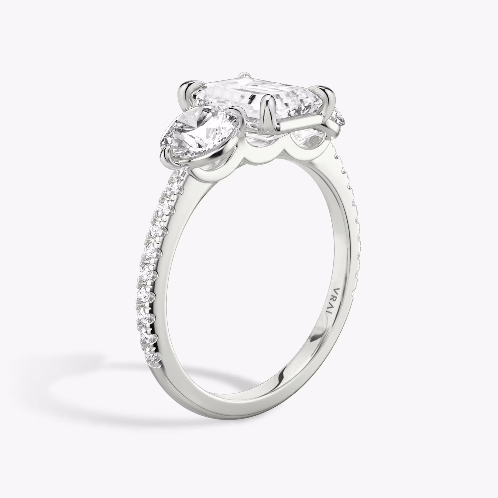 The Three Stone | Emerald | 18k | White Gold | bandAccent: Pavé | sideStoneCarat: 0.50ct | sideStoneShape: Round Brilliant | diamondOrientation: vertical | caratWeight: other