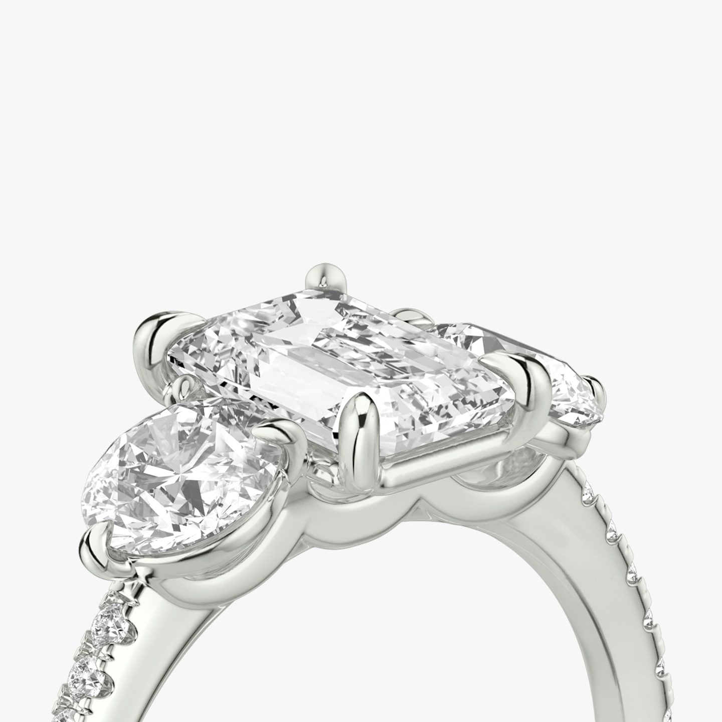 The Three Stone | Emerald | Platinum | bandAccent: Pavé | sideStoneCarat: 0.50ct | sideStoneShape: Round Brilliant | diamondOrientation: vertical | caratWeight: other