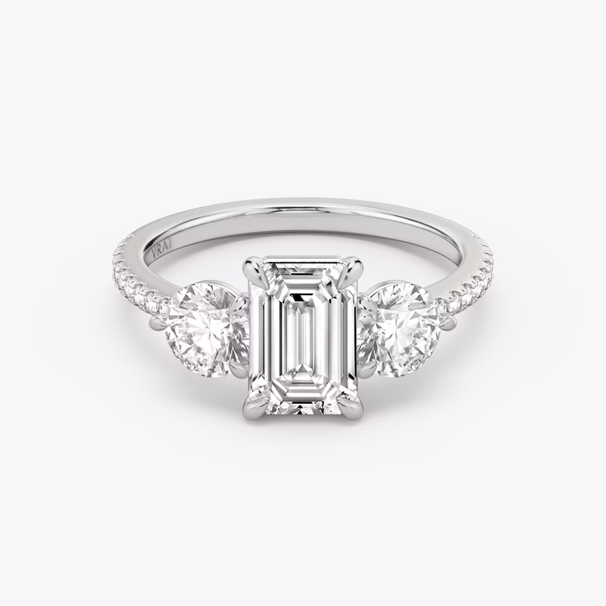 The Three Stone | Emerald | Platinum | bandAccent: Pavé | sideStoneCarat: 0.50ct | sideStoneShape: Round Brilliant | diamondOrientation: vertical | caratWeight: other