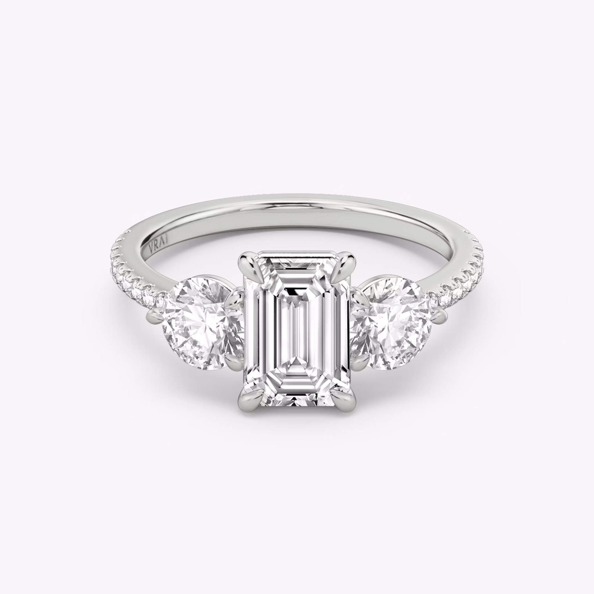 The Three Stone | Emerald | Platinum | bandAccent: Pavé | sideStoneCarat: 0.50ct | sideStoneShape: Round Brilliant | diamondOrientation: vertical | caratWeight: other