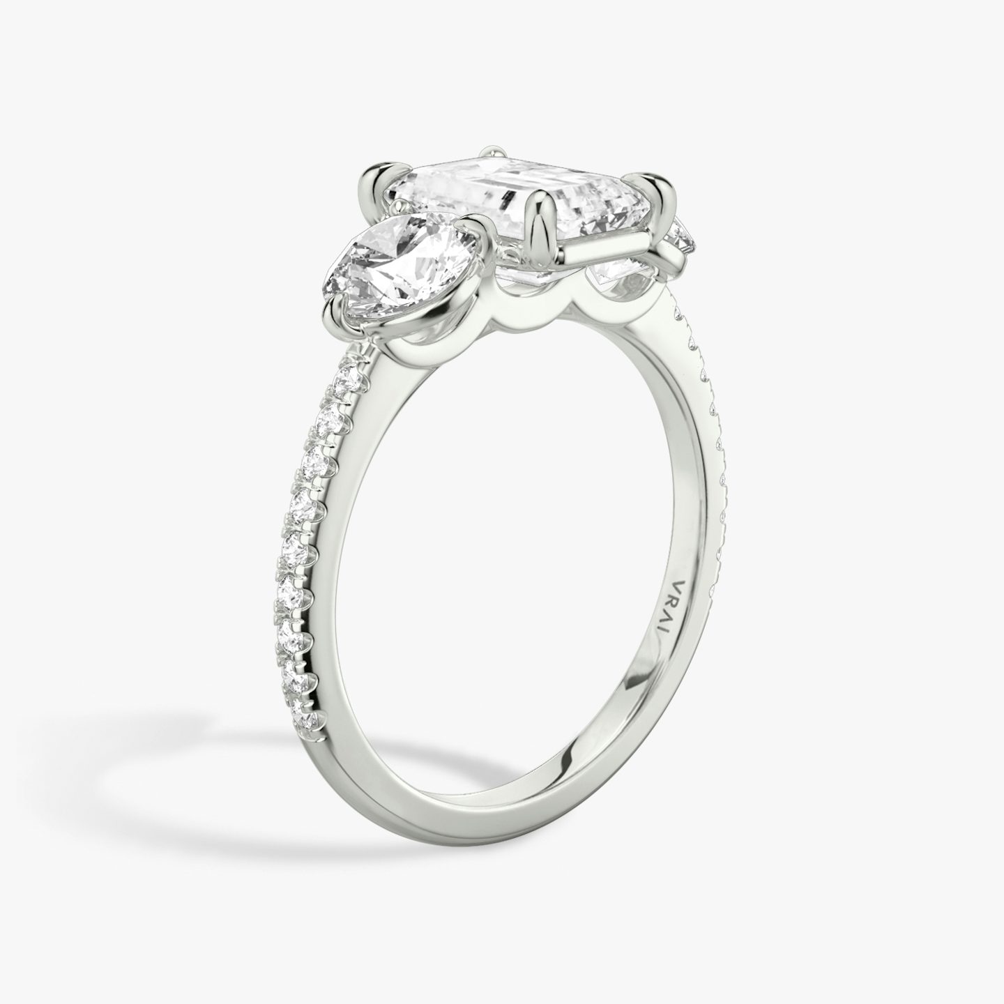 The Three Stone | Emerald | Platinum | bandAccent: Pavé | sideStoneCarat: 0.50ct | sideStoneShape: Round Brilliant | diamondOrientation: vertical | caratWeight: other