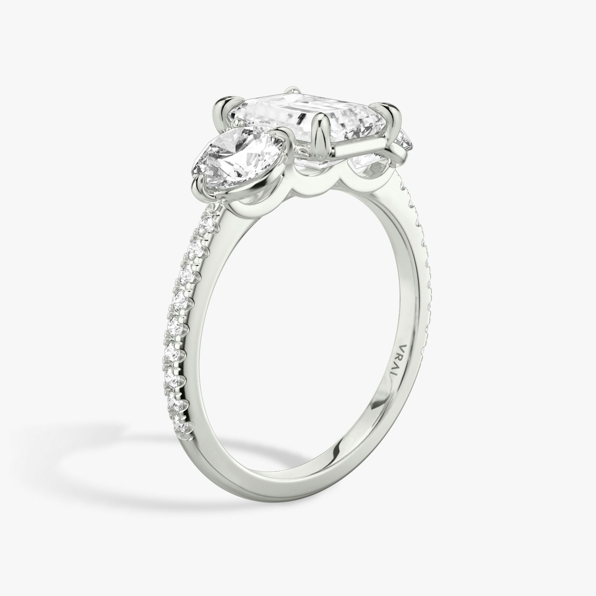 The Three Stone | Emerald | Platinum | bandAccent: Pavé | sideStoneCarat: 0.50ct | sideStoneShape: Round Brilliant | diamondOrientation: vertical | caratWeight: other