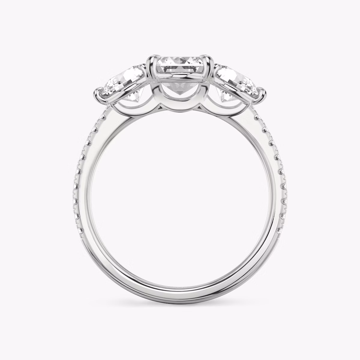 The Three Stone | Emerald | Platinum | bandAccent: Pavé | sideStoneCarat: 0.50ct | sideStoneShape: Round Brilliant | diamondOrientation: vertical | caratWeight: other