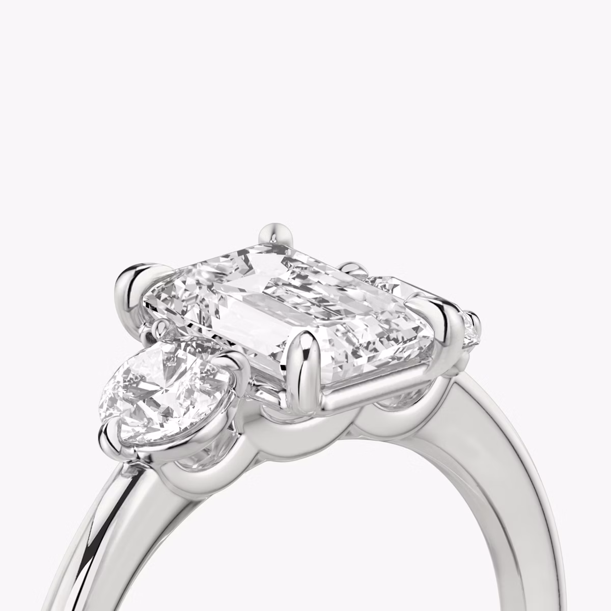 The Three Stone | Emerald | Platinum | bandAccent: Plain | sideStoneCarat: 0.25ct | sideStoneShape: Round Brilliant | diamondOrientation: vertical | caratWeight: other