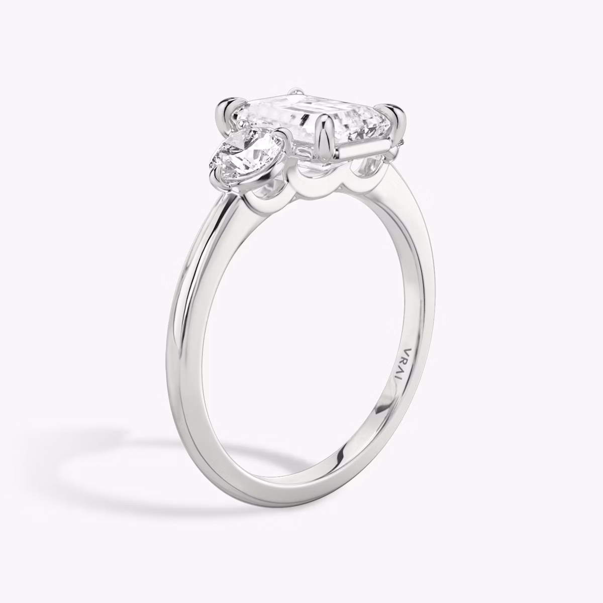 The Three Stone | Emerald | Platinum | bandAccent: Plain | sideStoneCarat: 0.25ct | sideStoneShape: Round Brilliant | diamondOrientation: vertical | caratWeight: other