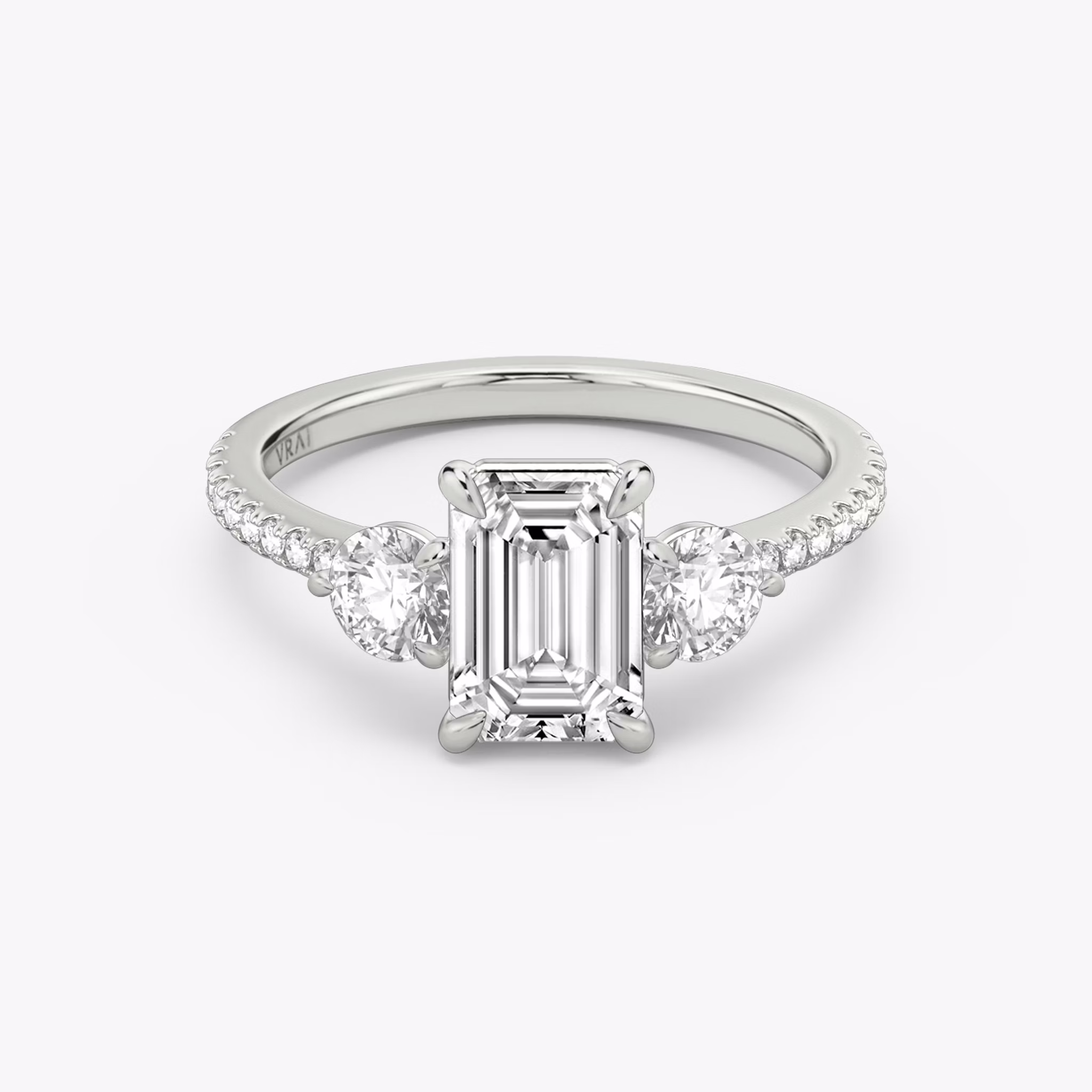The Three Stone | Emerald | 18k | White Gold | bandAccent: Pavé | sideStoneCarat: 0.25ct | sideStoneShape: Round Brilliant | diamondOrientation: vertical | caratWeight: other