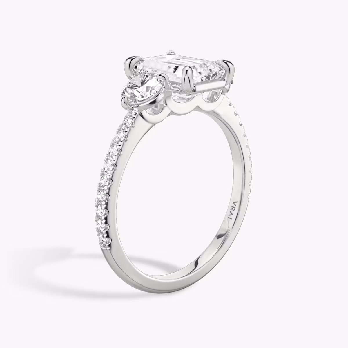 The Three Stone | Emerald | 18k | White Gold | bandAccent: Pavé | sideStoneCarat: 0.25ct | sideStoneShape: Round Brilliant | diamondOrientation: vertical | caratWeight: other