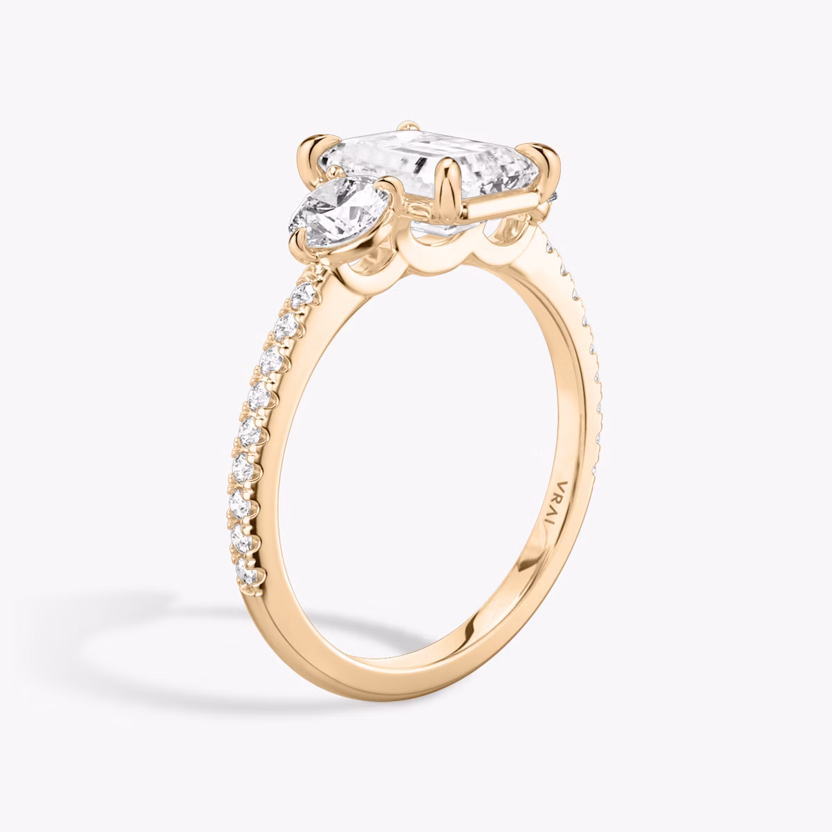 The Three Stone | Emerald | 14k | Rose Gold | bandAccent: Pavé | sideStoneCarat: 0.25ct | sideStoneShape: Round Brilliant | diamondOrientation: vertical | caratWeight: other