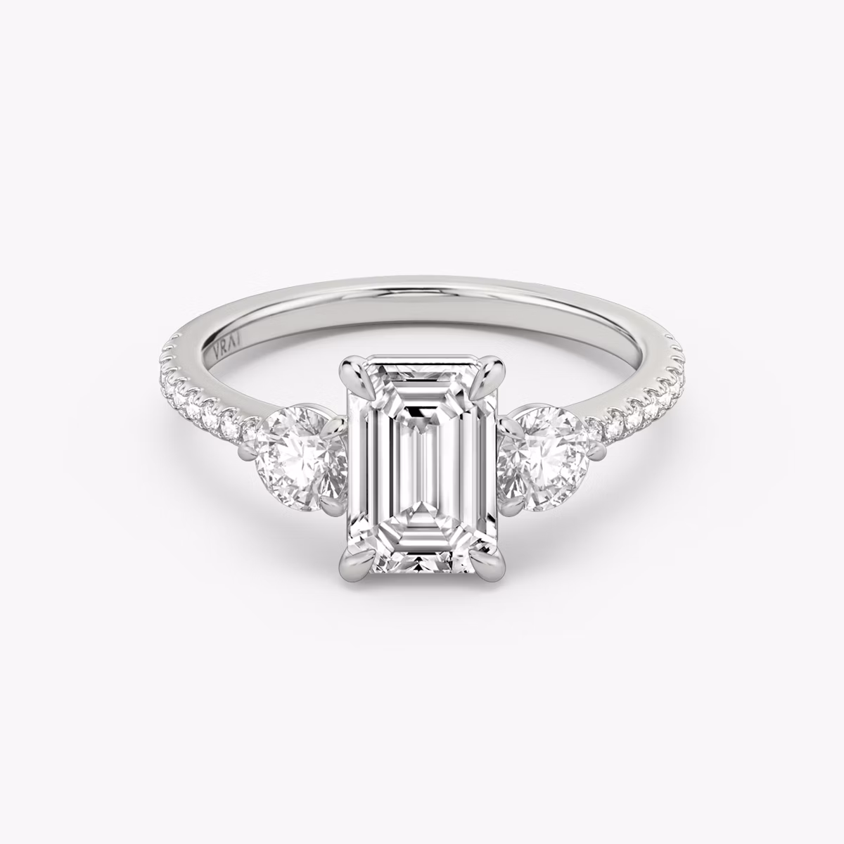 The Three Stone | Emerald | Platinum | bandAccent: Pavé | sideStoneCarat: 0.25ct | sideStoneShape: Round Brilliant | diamondOrientation: vertical | caratWeight: other