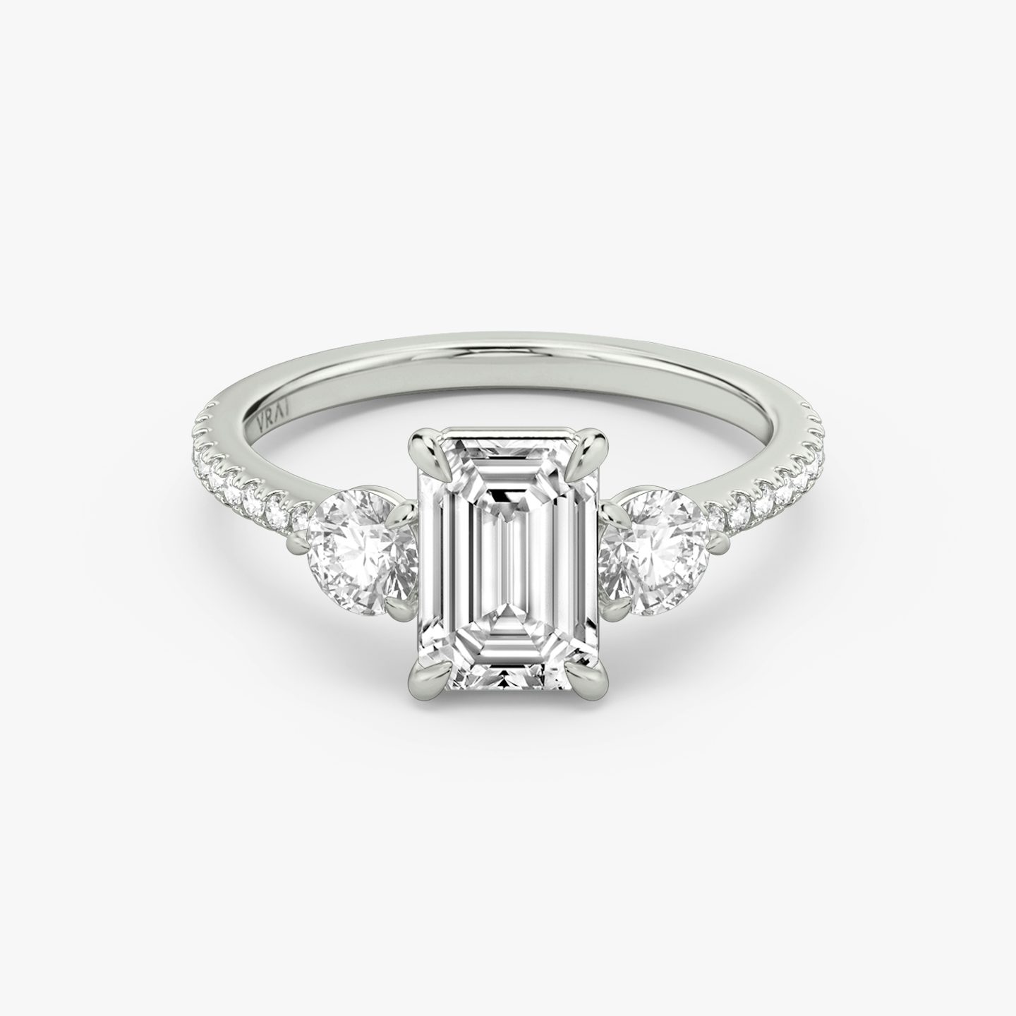 The Three Stone | Emerald | Platinum | bandAccent: Pavé | sideStoneCarat: 0.25ct | sideStoneShape: Round Brilliant | diamondOrientation: vertical | caratWeight: other