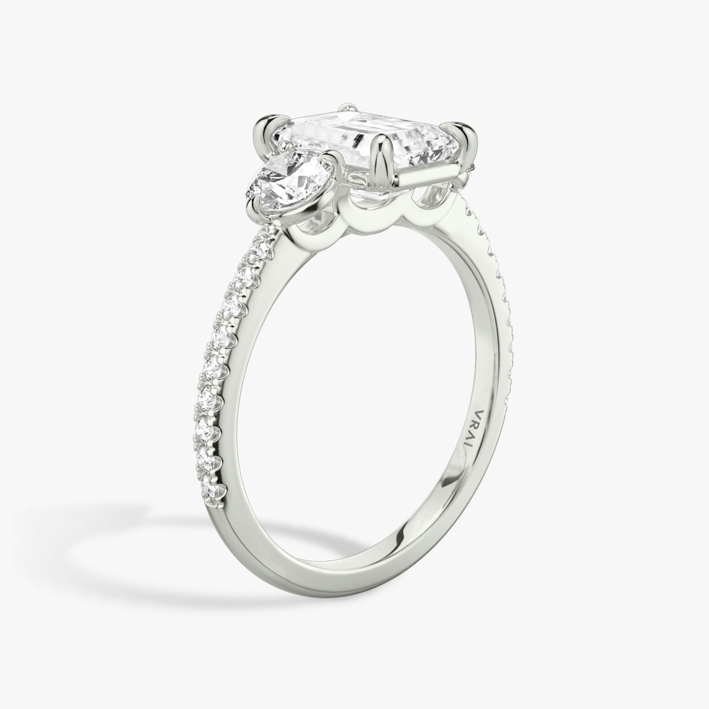 The Three Stone | Emerald | Platinum | bandAccent: Pavé | sideStoneCarat: 0.25ct | sideStoneShape: Round Brilliant | diamondOrientation: vertical | caratWeight: other