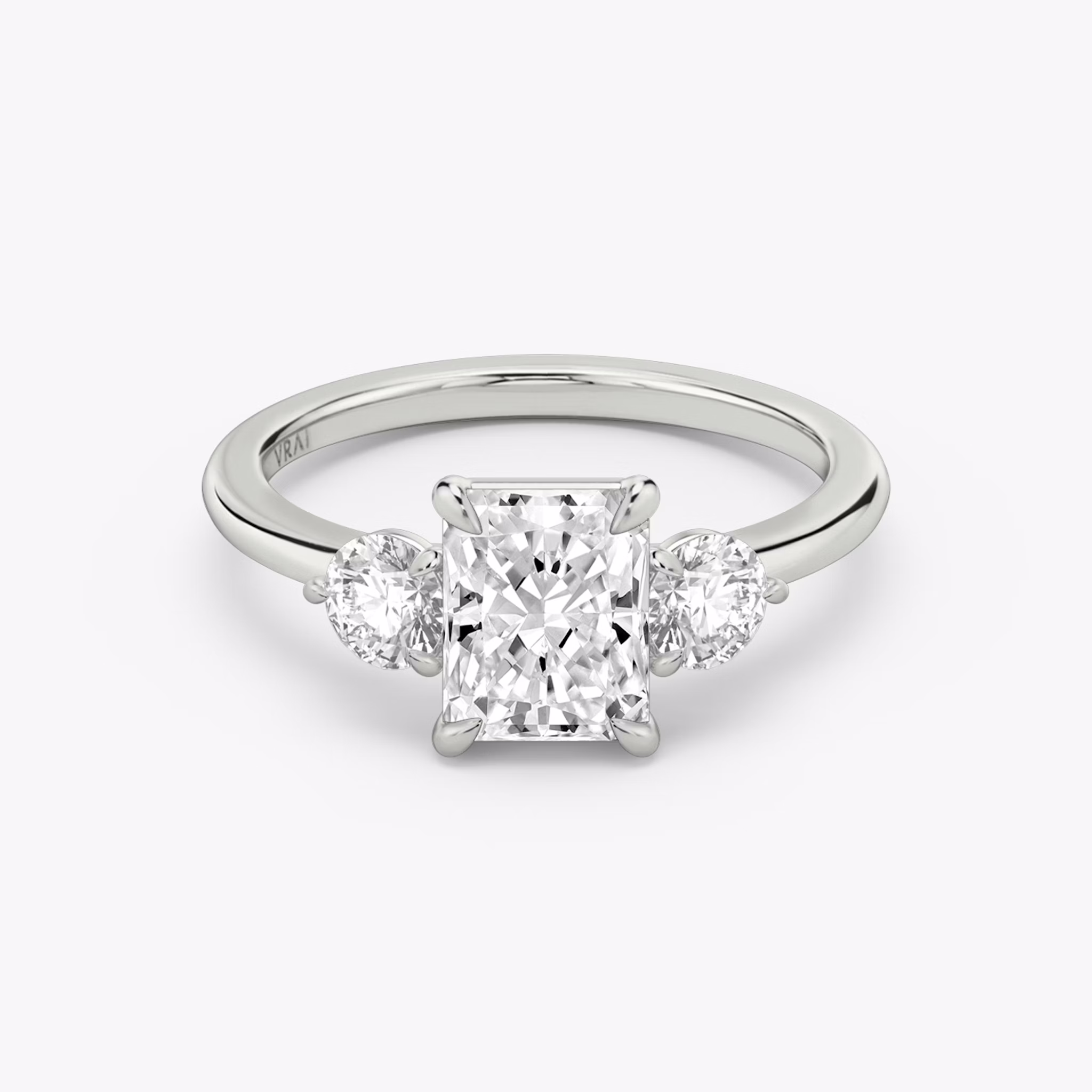 The Three Stone | Radiant | 18k | White Gold | bandAccent: Plain | sideStoneCarat: 0.25ct | sideStoneShape: Round Brilliant | diamondOrientation: vertical | caratWeight: other
